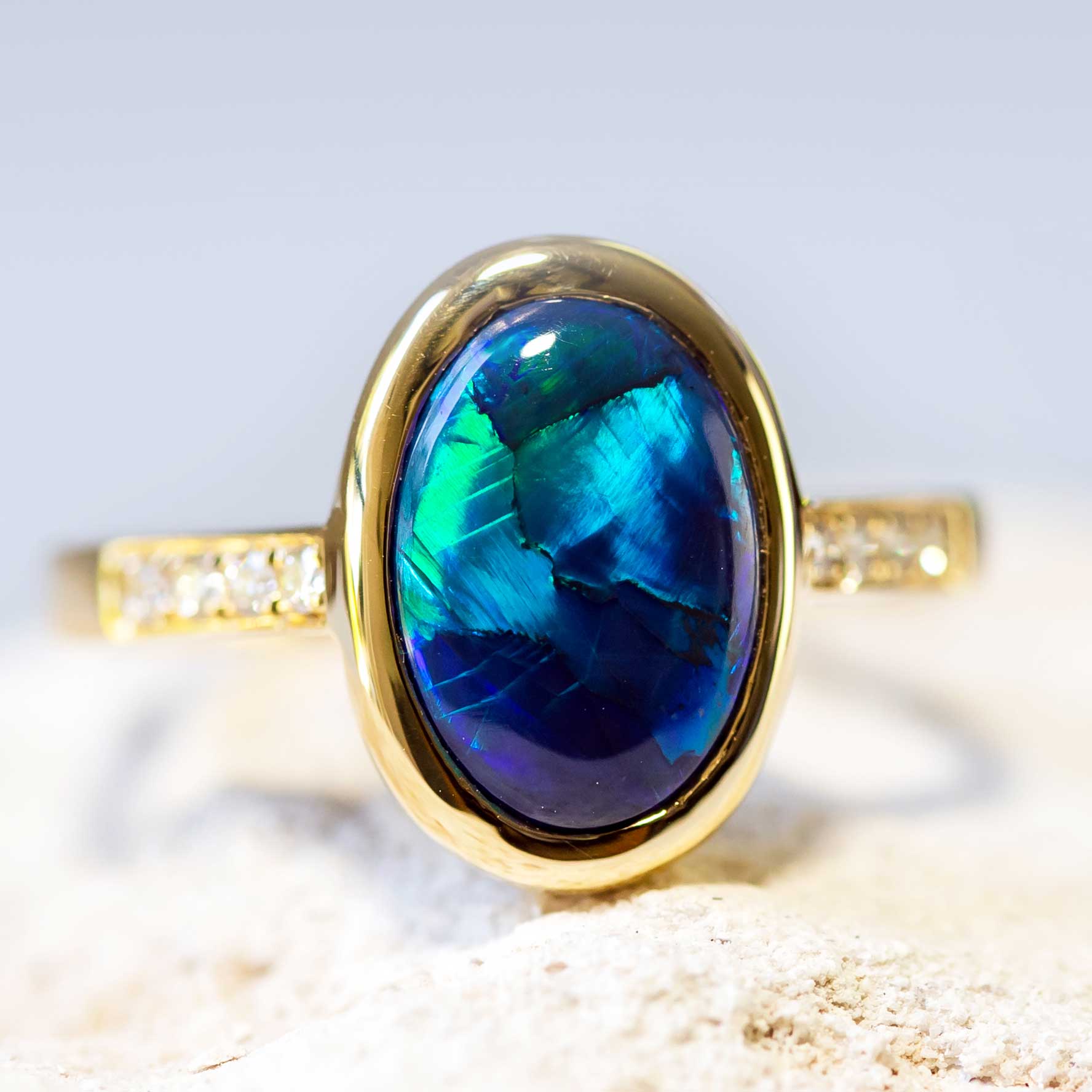 Black opal ring with blue and green colours and diamonds