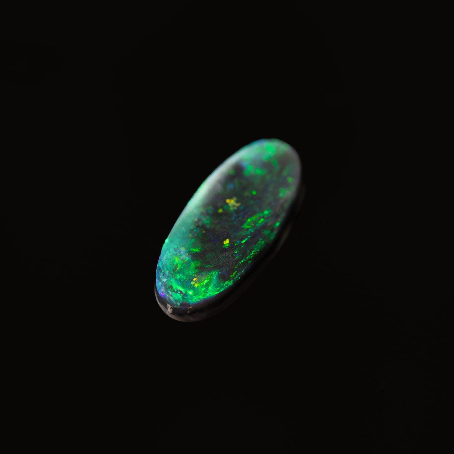 Genuine Lightning Ridge black opal gemstone showing vibrant green play-of-colour