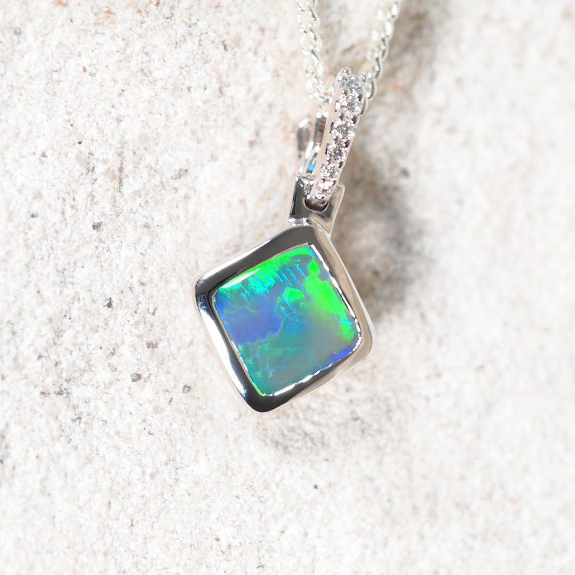 Black opal pendant necklace on a textured white background
