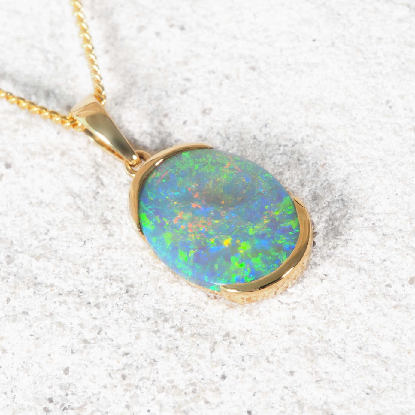 Opal pendant necklace on a textured white background