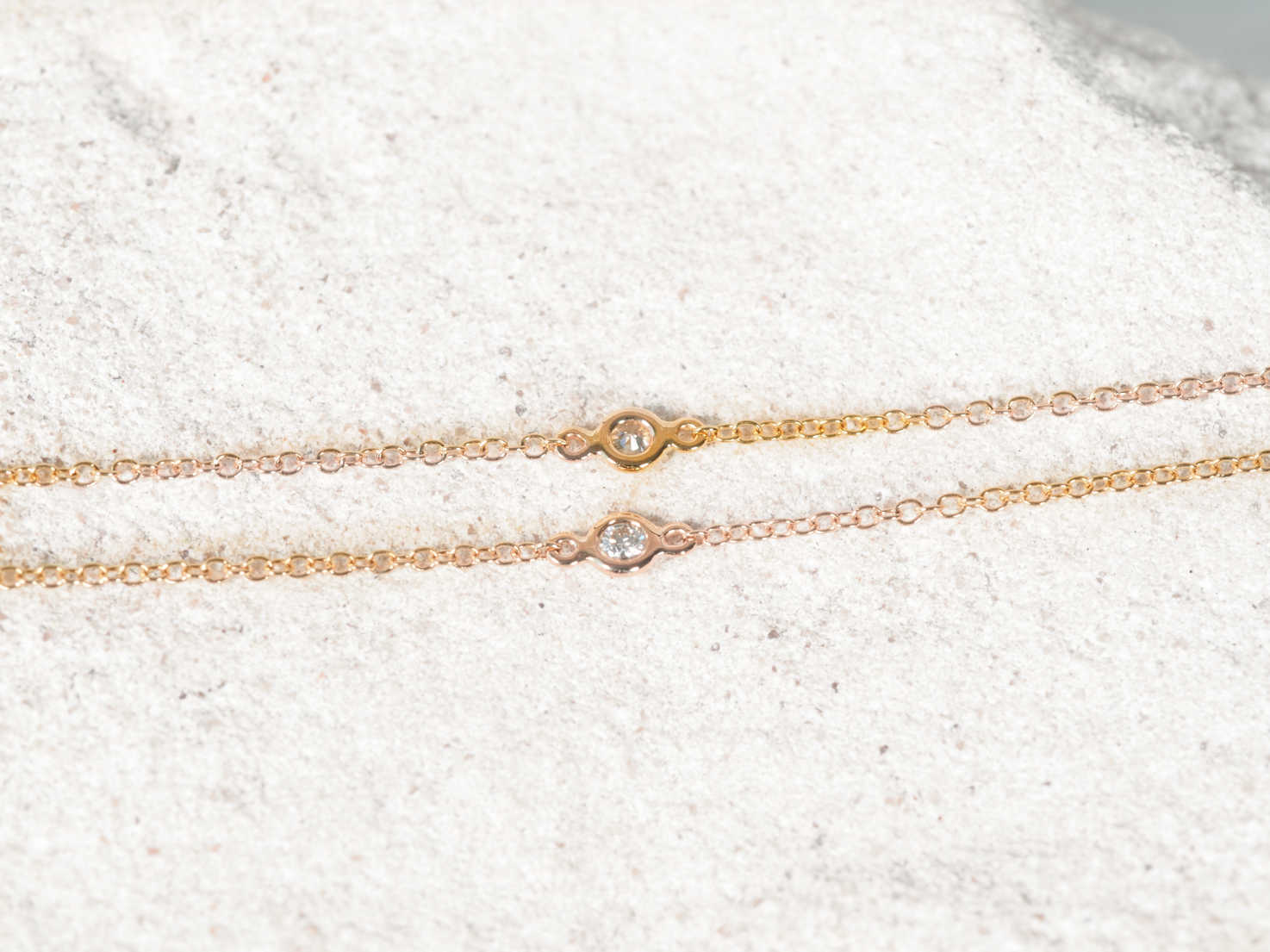two bezel set diamonds set into a luxurious 14ct yellow gold chain