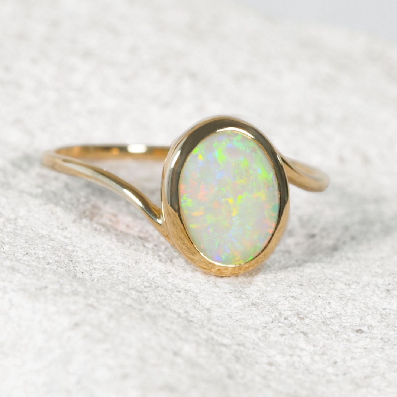 14ct yellow gold Australian crystal opal ring featuring a genuine oval Coober Pedy solid opal in a polished bezel setting