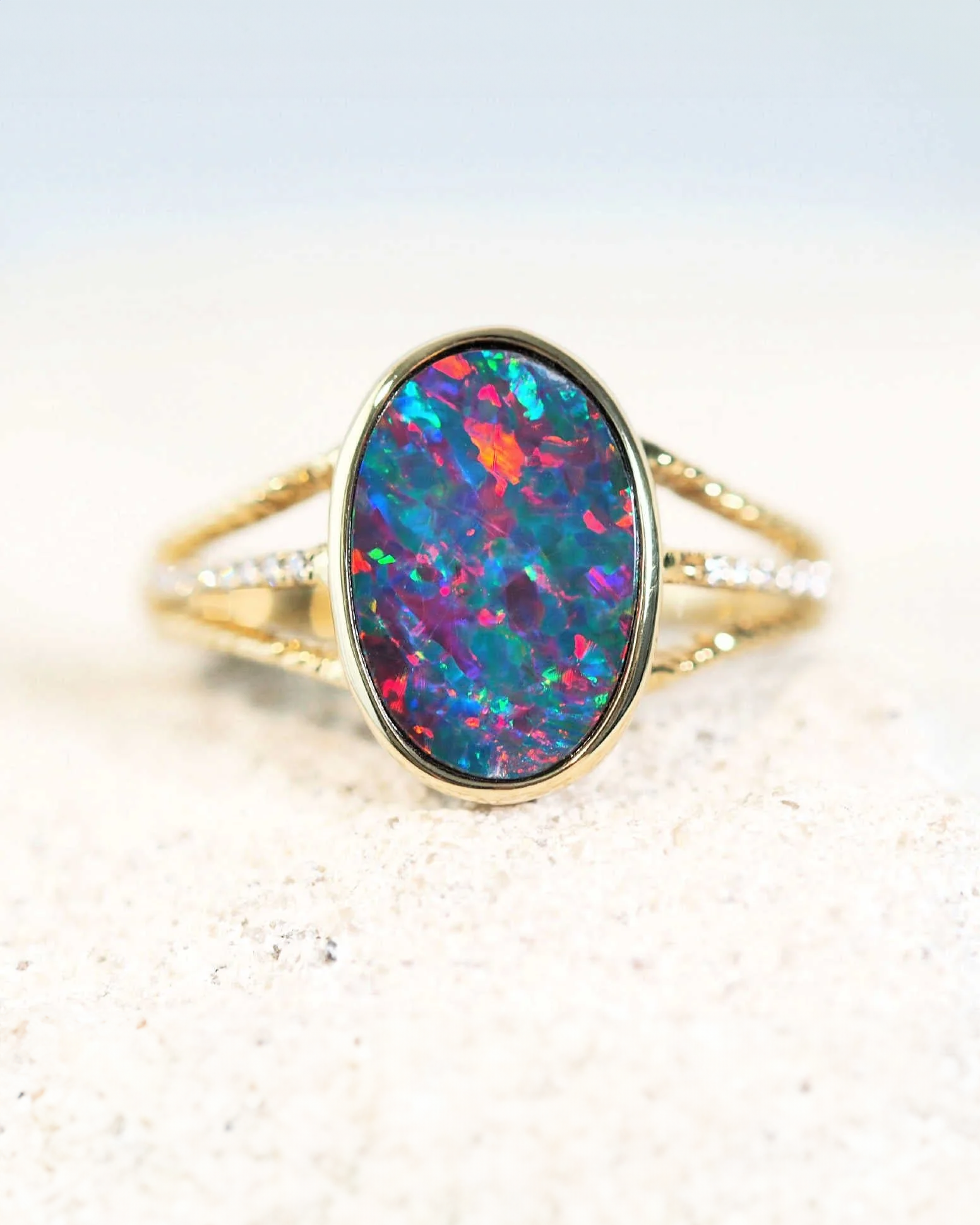 An opal ring set in gold with three bands by Black Star Opal