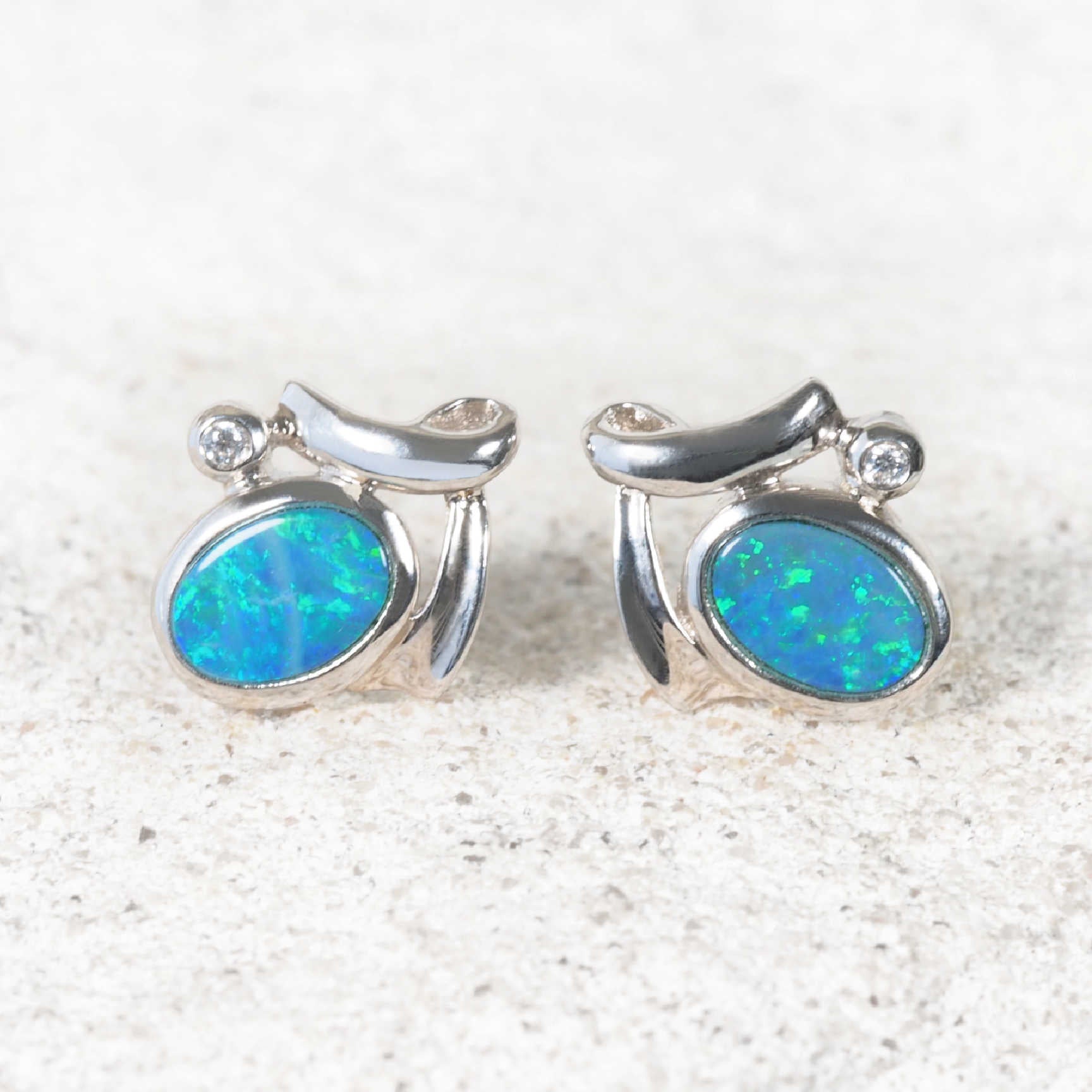 Oval-shaped Australian doublet opal earrings with vivid colour and bezel setting