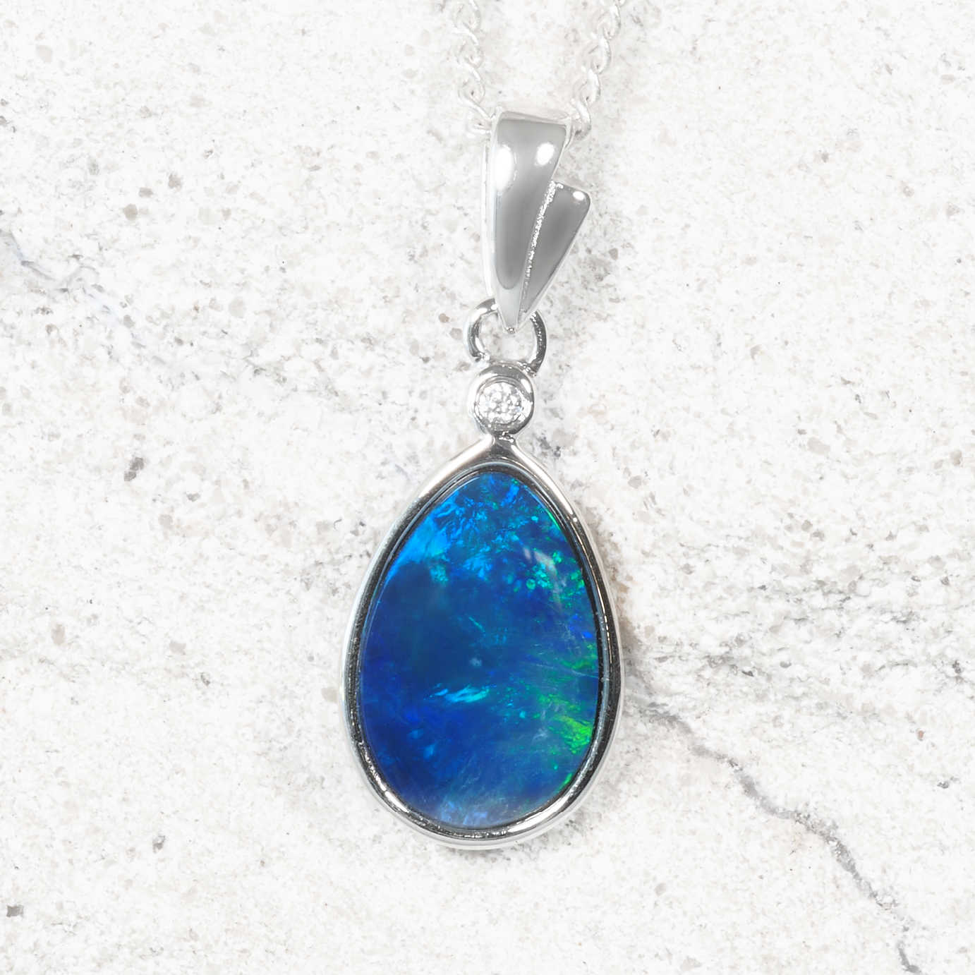 Genuine Australian opal doublet pendant in sterling silver with vivid blue and green play-of-colour and cubic zirconia accent