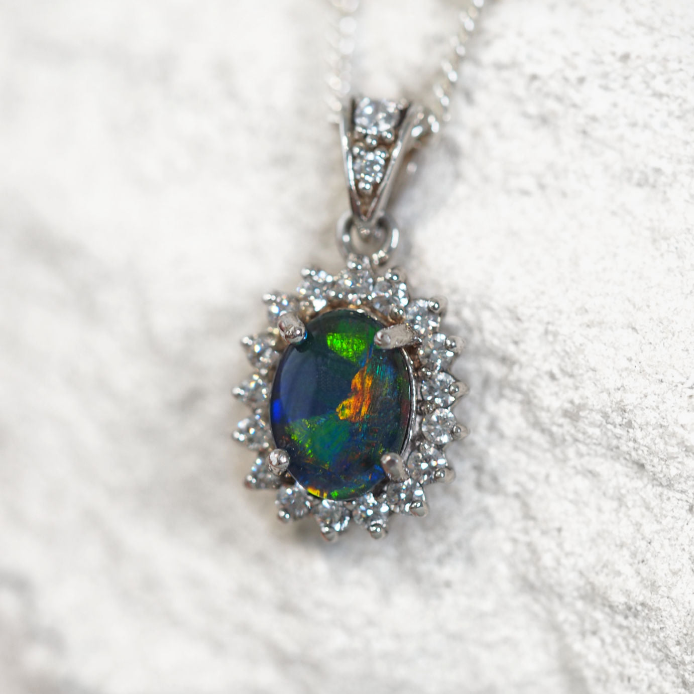 Elegant sterling silver necklace pendant featuring vibrant multi-coloured Australian triplet opal surrounded by 19 sparkling diamantés