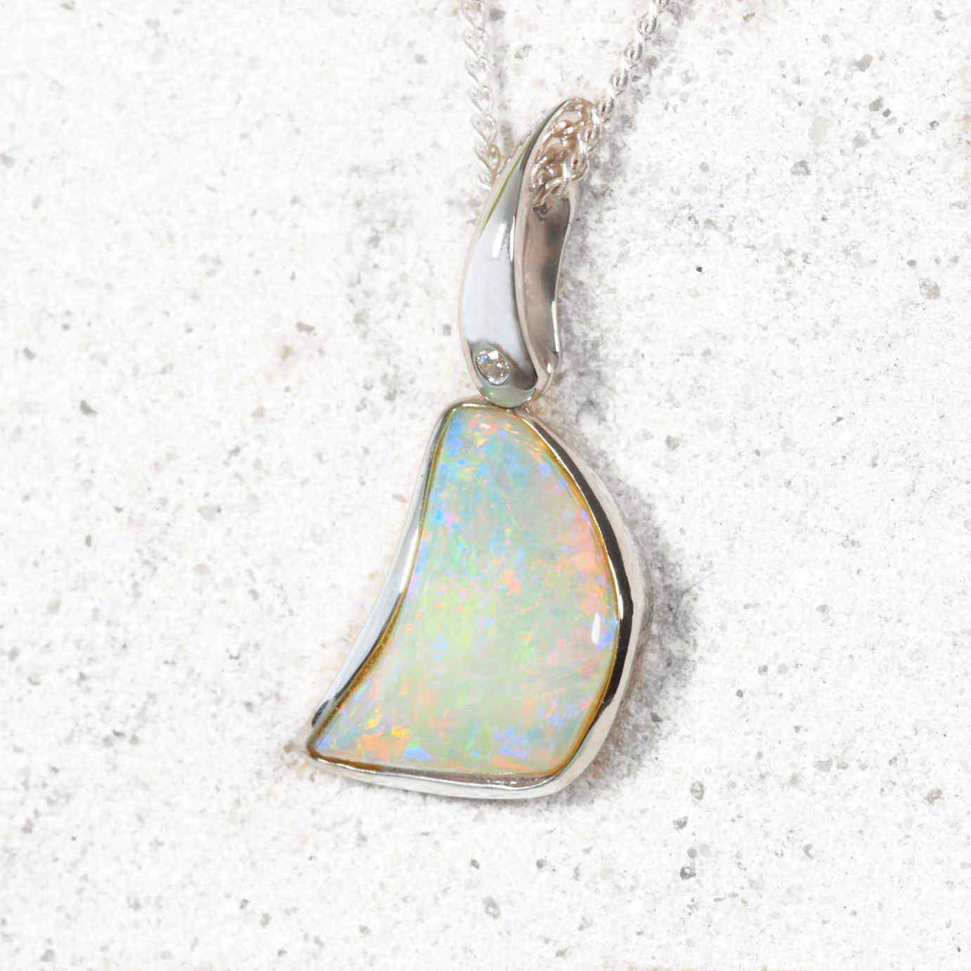 14ct white gold pendant with uniquely shaped Coober Pedy solid white opal and bezel-set diamond accent