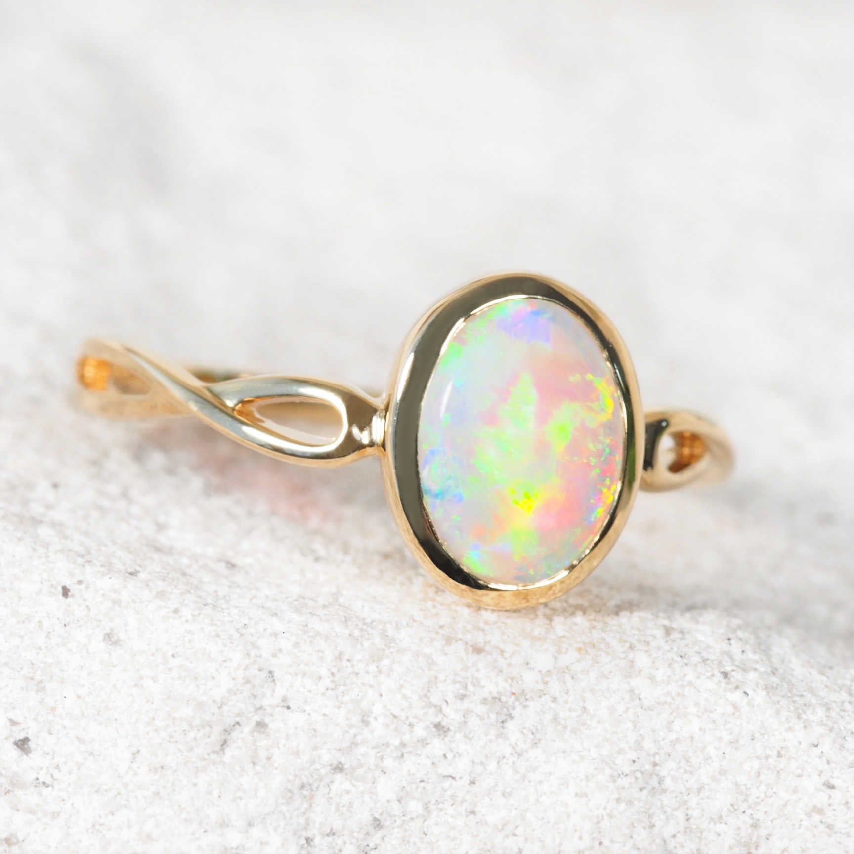 Close-up of bezel-set oval opal ring with vibrant play-of-colour