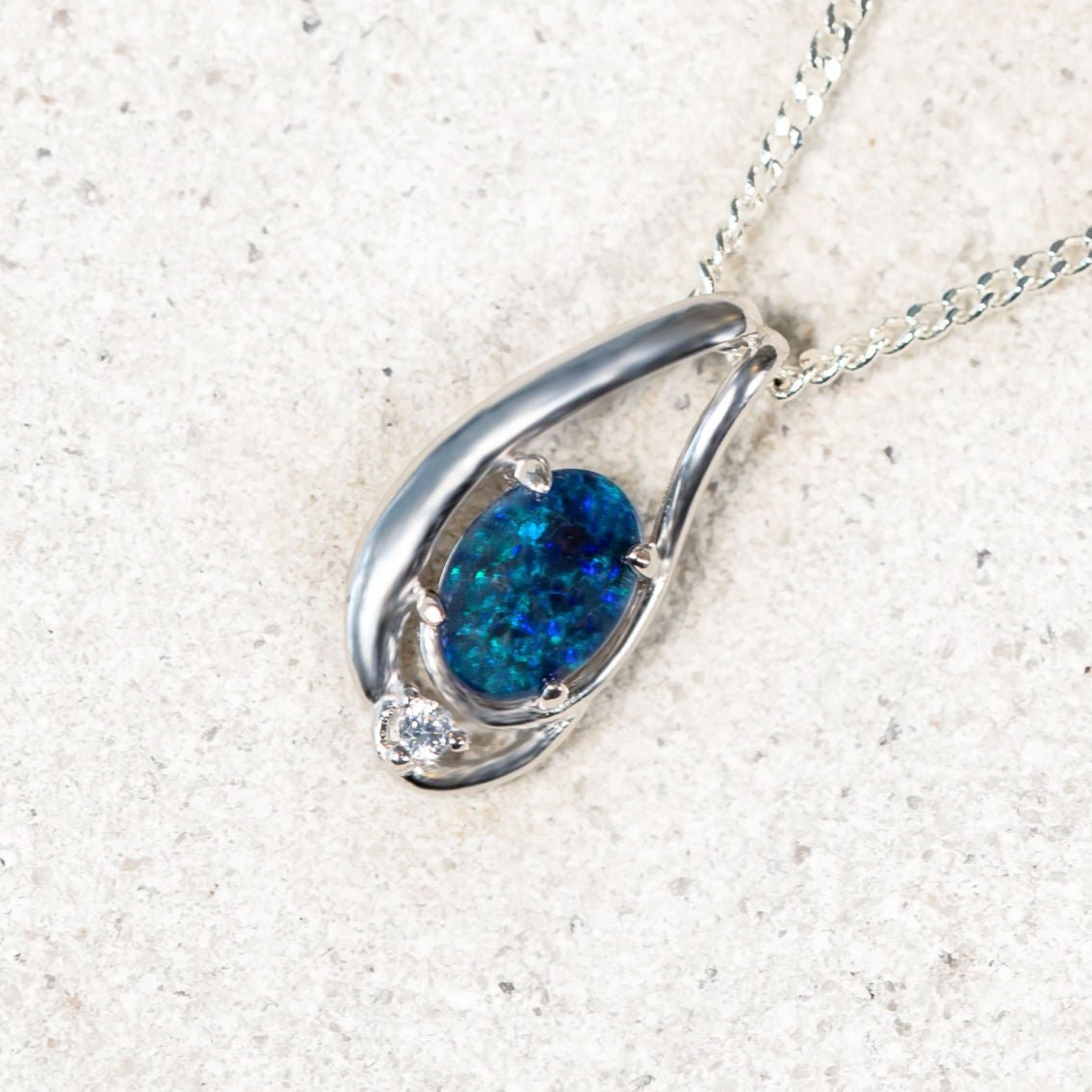 silver opal pendant with a blue and green opal gemstone