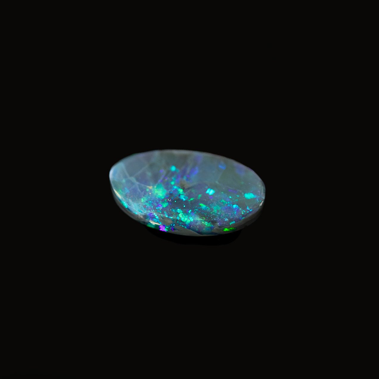 Oval-shaped black opal from Lightning Ridge with deep midnight body tone