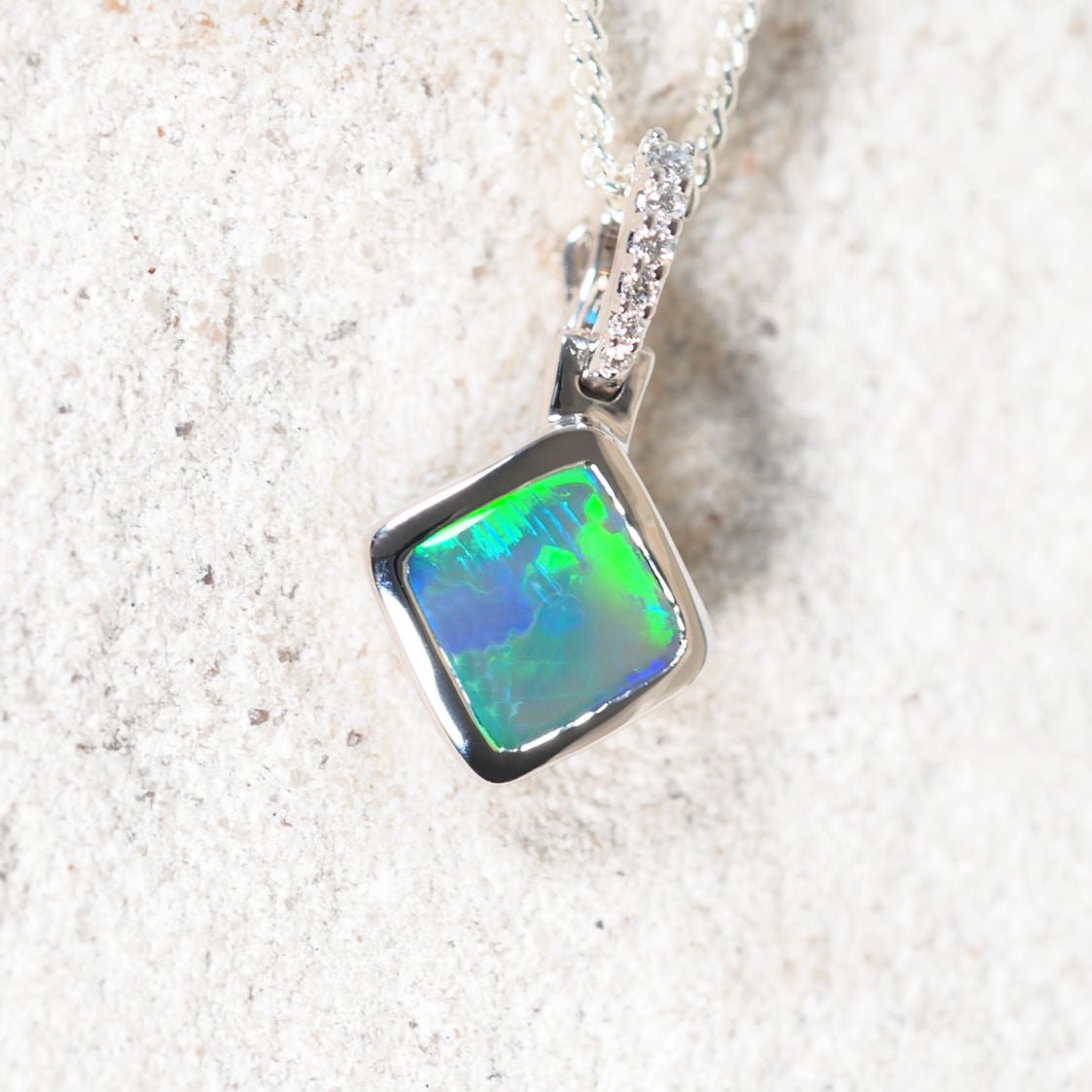 Black opal pendant necklace on a textured white background