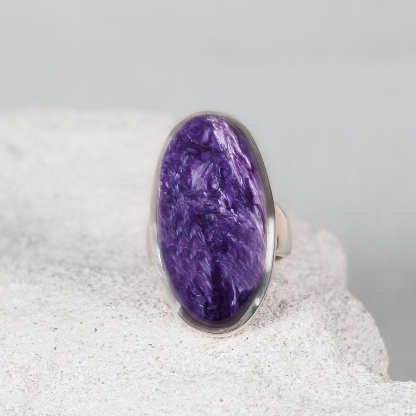 Oval Charoite ring in polished silver showcasing violet and lavender hues with soft natural patterns
