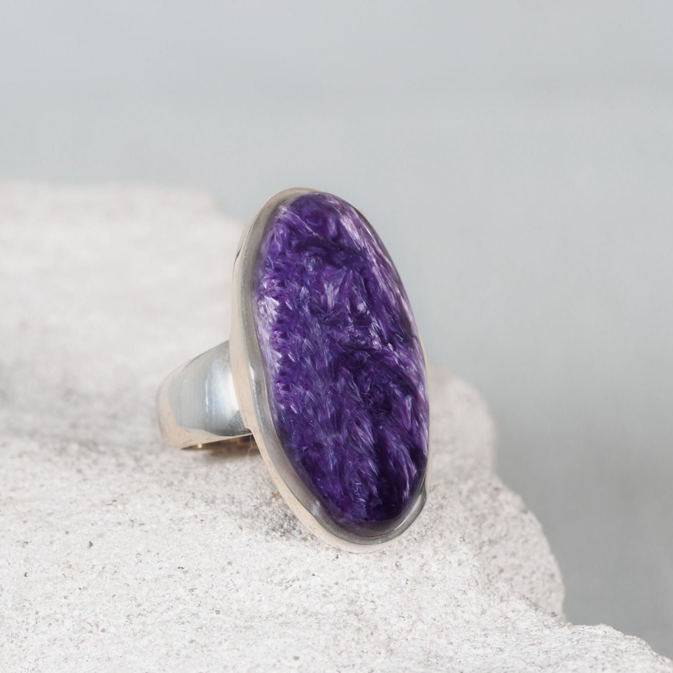Silver ring featuring an oval Charoite gemstone with blended purple and white tones in a sleek bezel setting