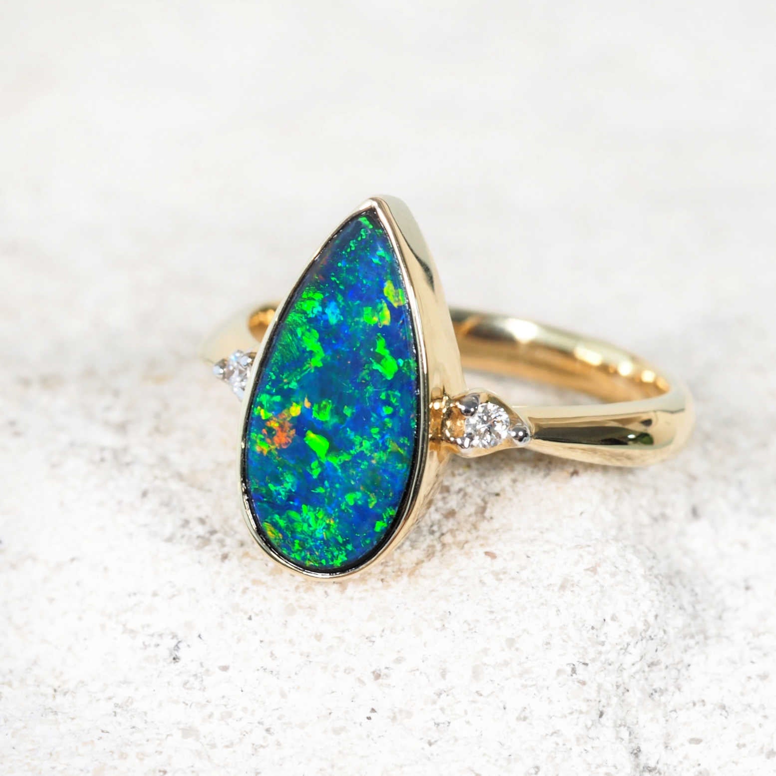 Teardrop opal doublet ring set in yellow gold with bezel-set diamonds