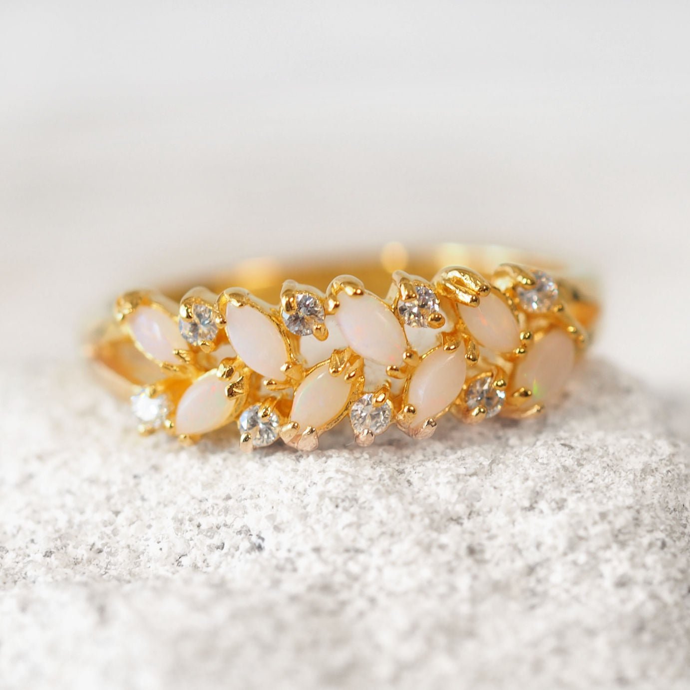 Gold ring with opal stones on a white background