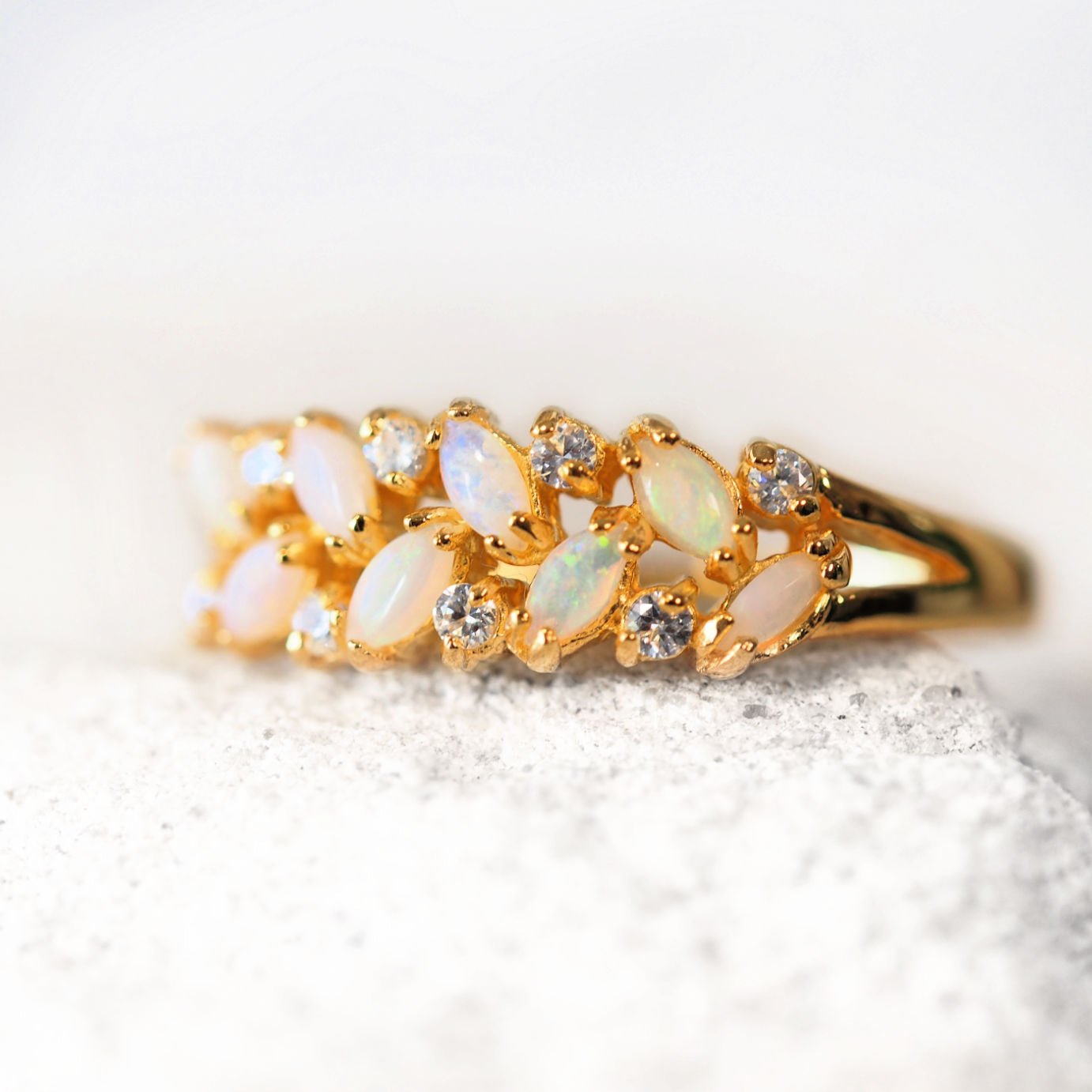 Gold ring with opal stones on a white background