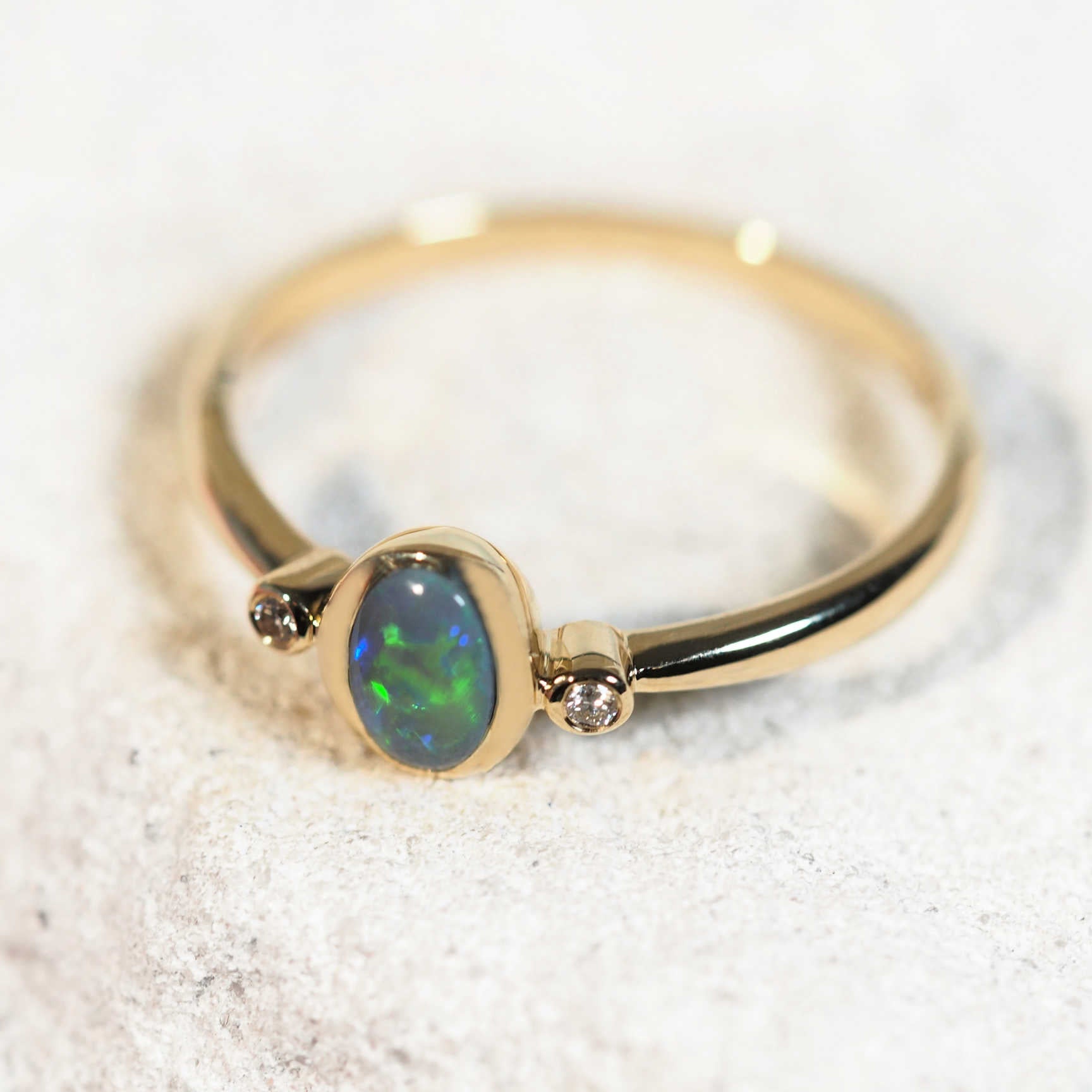 Elegant black opal ring featuring a vibrant, gemstone set in a polished gold band