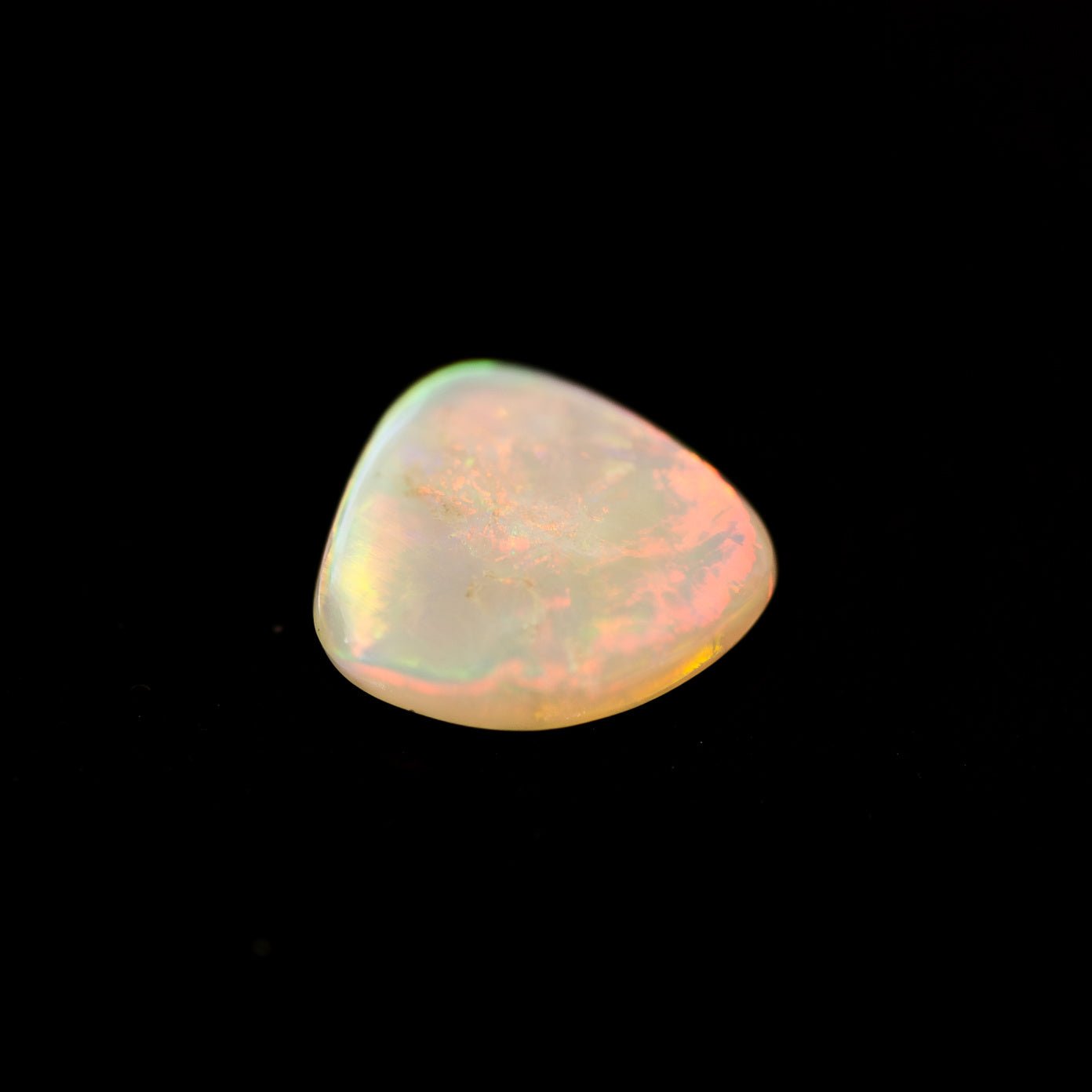 Polished opal stone on a black background