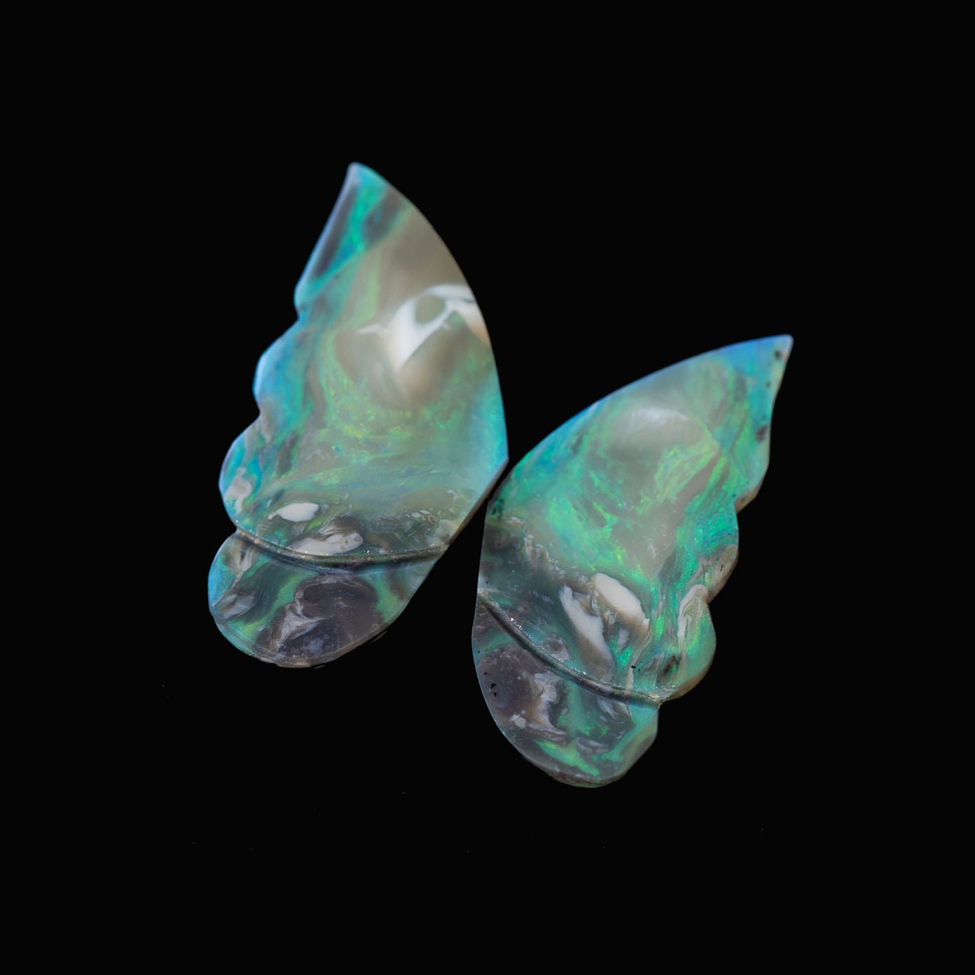 Black opal stones with a butterfly wing design on a black background
