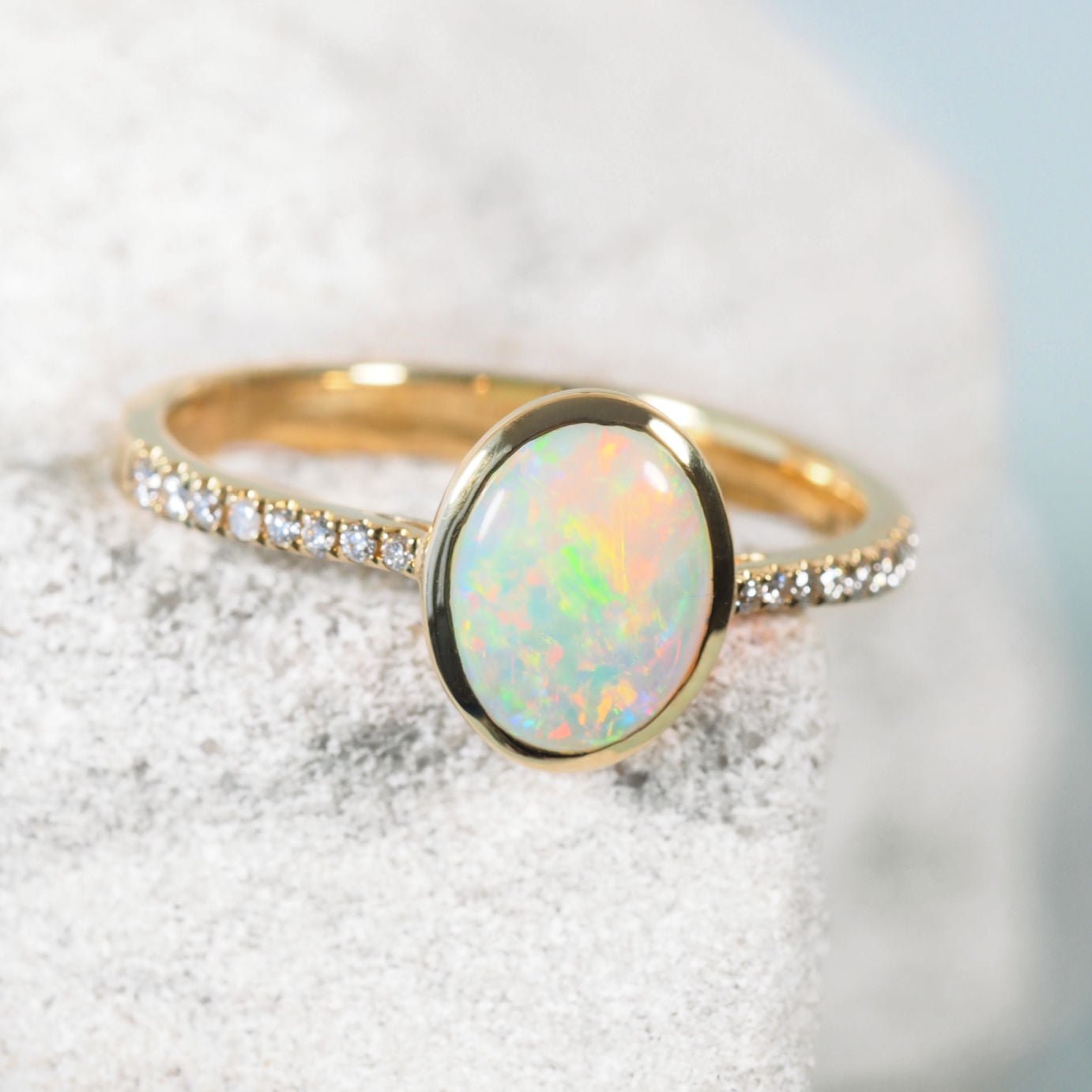 Elegant 14ct yellow gold opal engagement ring featuring Australian crystal opal with vibrant play-of-colour and sparkling diamond accents