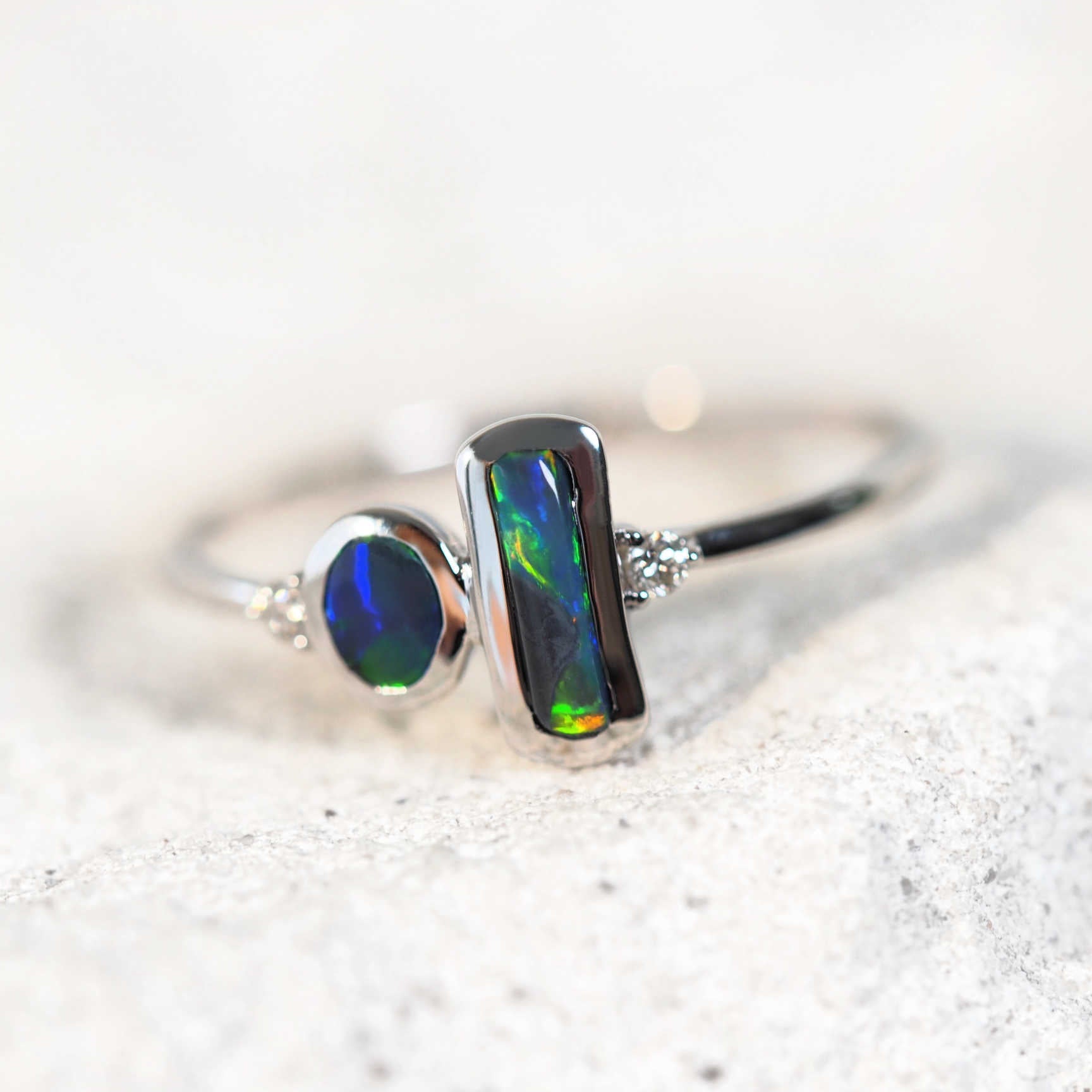 white gold black opal ring with two shoulder set diamonds