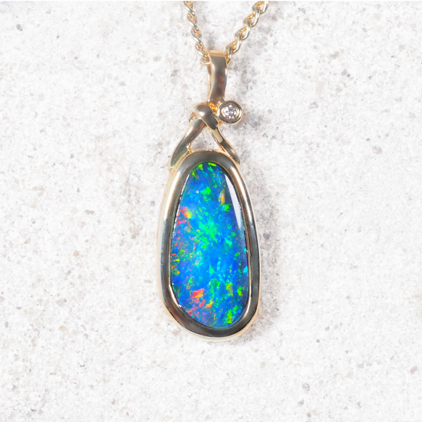 Opal pendant necklace on a textured white background