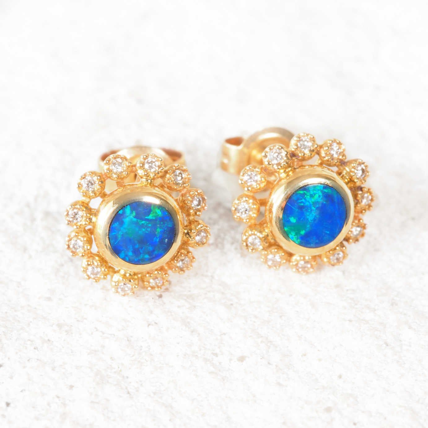 14ct gold earrings featuring blue-green opals surrounded by white diamonds