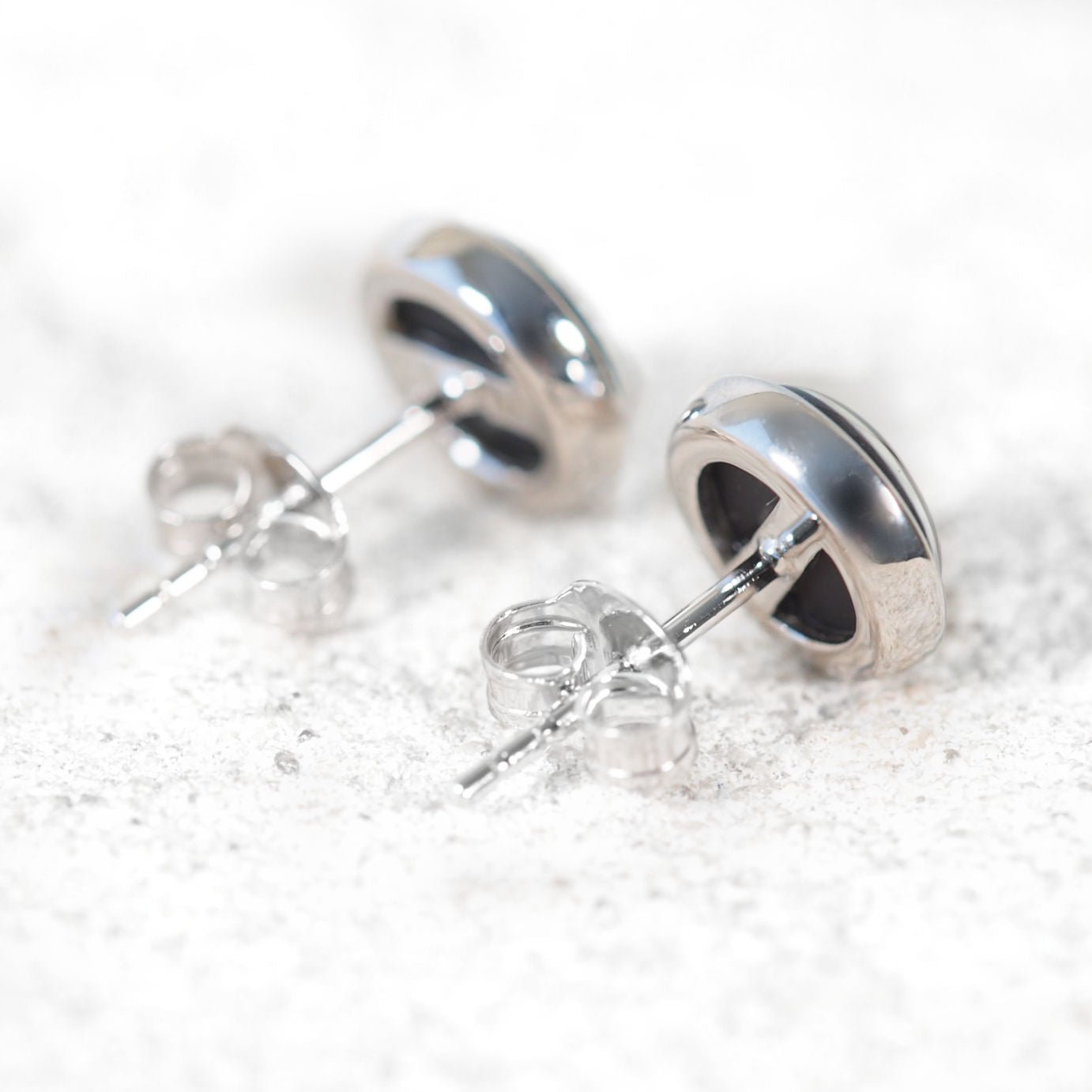 Silver opal stud earrings on a white background