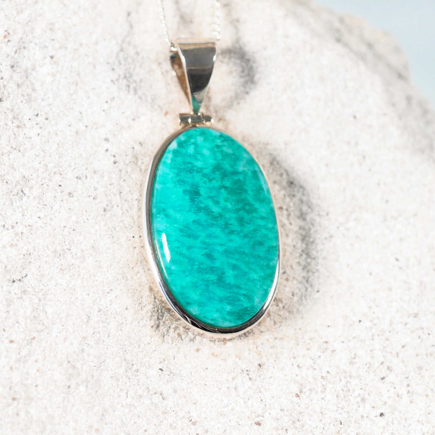 Close-up of the 'Cleo' pendant with smooth oval Amazonite in a sleek silver bezel, perfect for casual or elegant wear