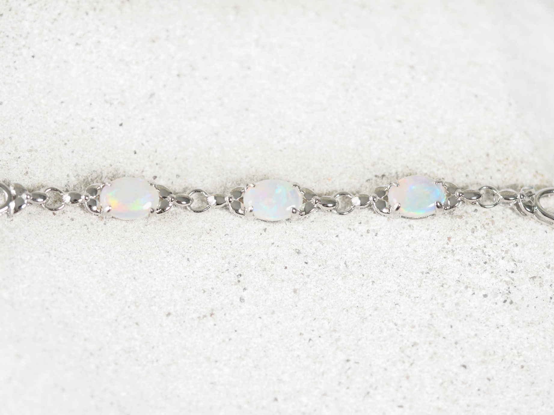 Silver bracelet with opal stones on a white background