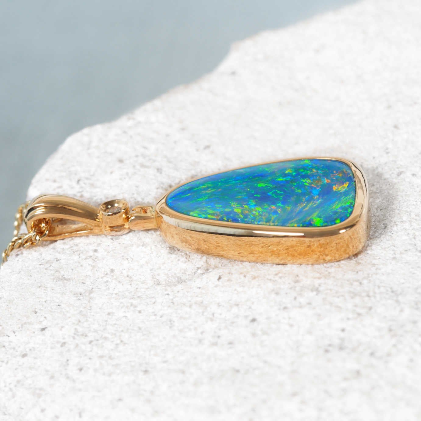 Luxury gold opal and diamond necklace featuring a bezel-set triangular opal