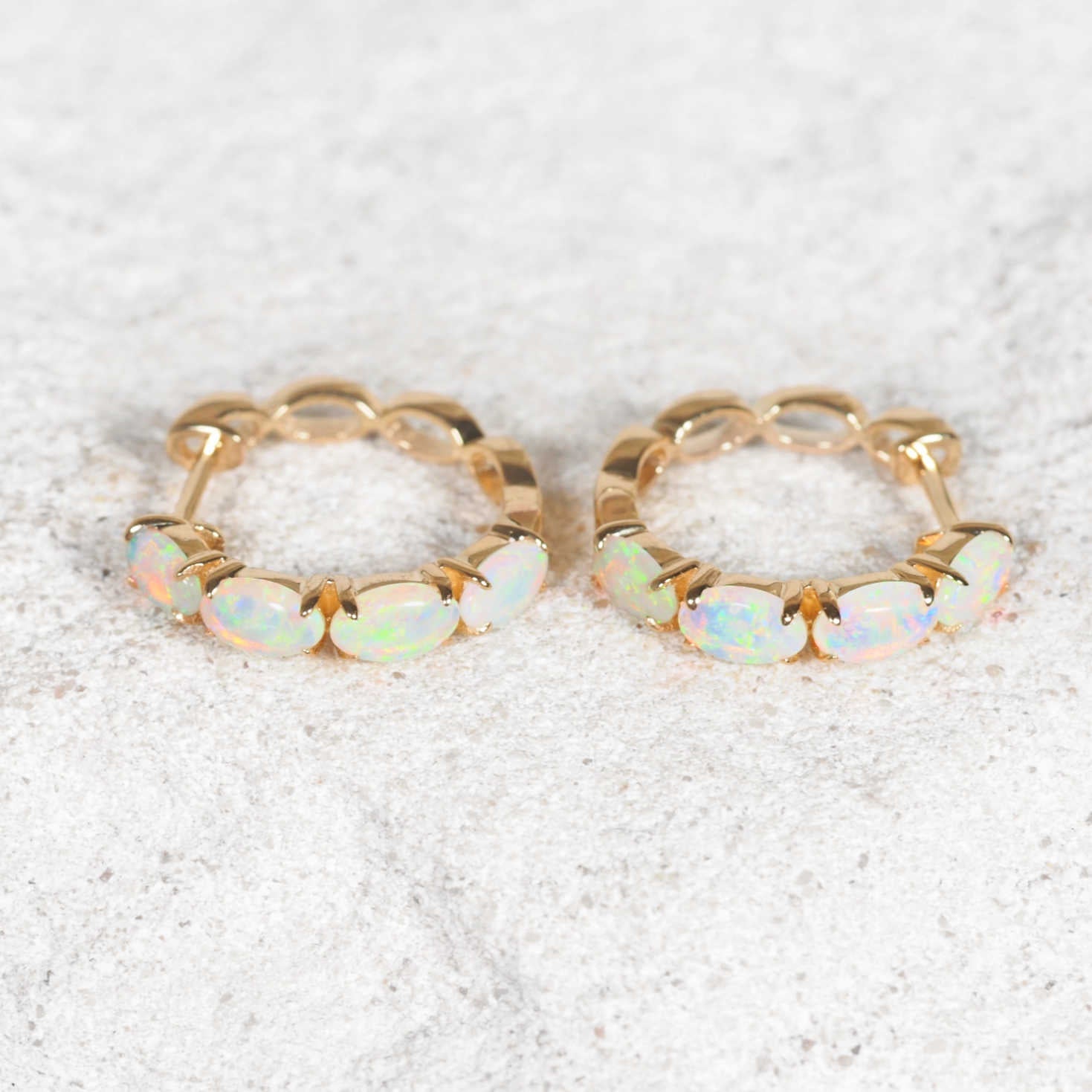 Elegant opal hoop earrings showcasing vibrant multi-colour play in yellow gold setting