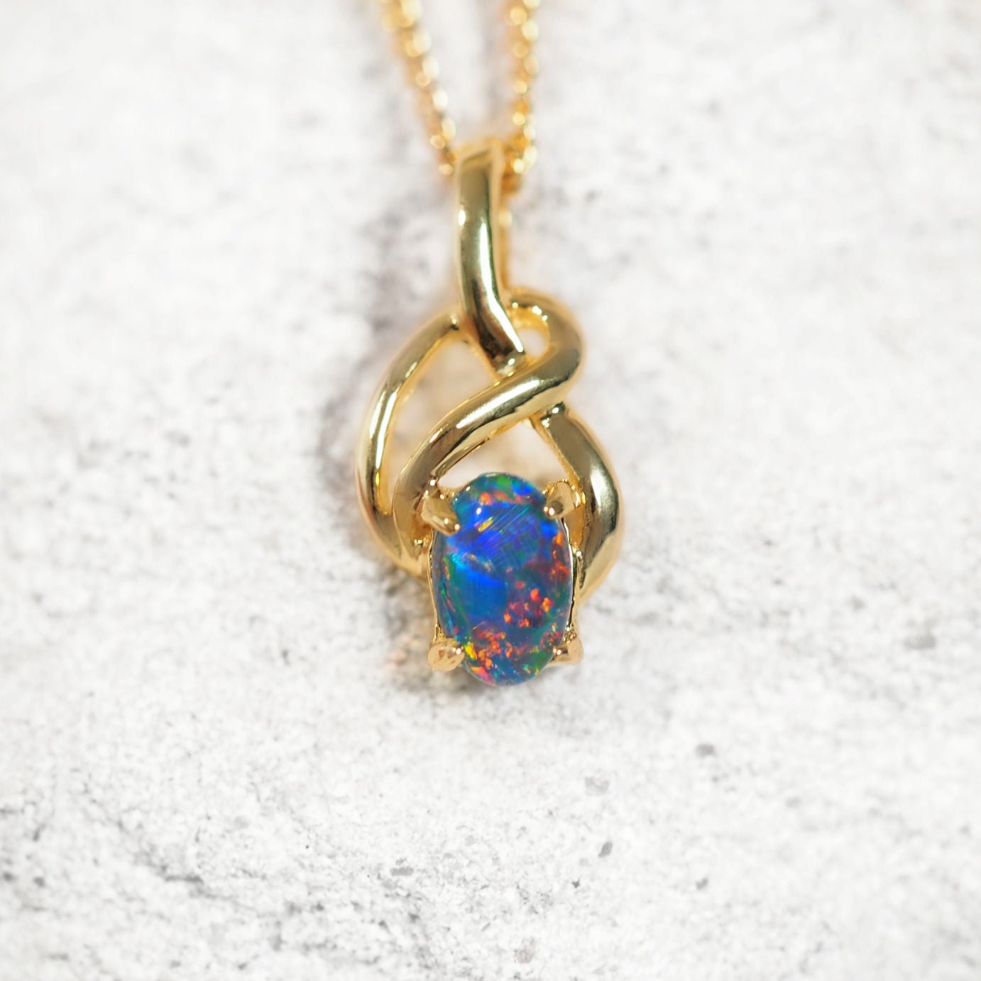 Eira opal pendant in gold-plated silver with Celtic twist design and claw-set oval Australian triplet opal