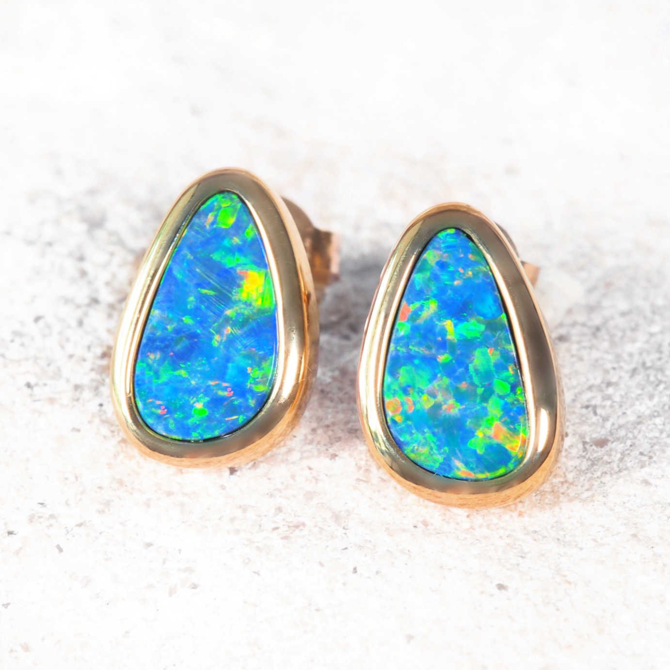 Elegant gold opal earrings featuring bezel-set multi-coloured doublet opals.