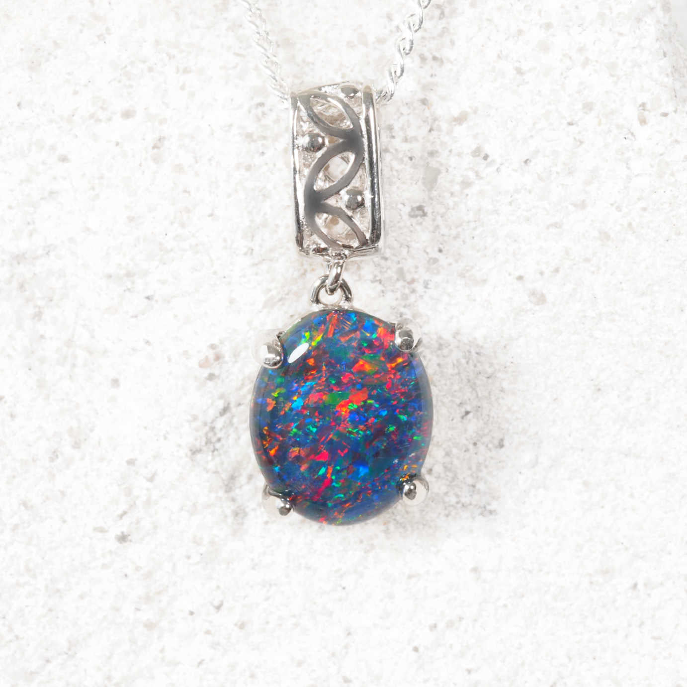 Opal pendant with silver setting on a white background