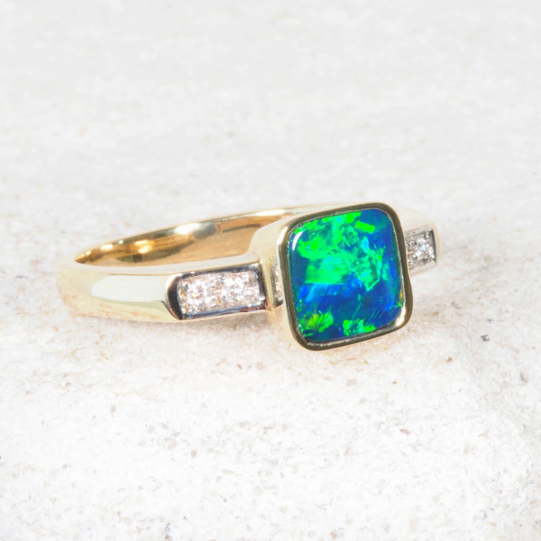 Blue and green opal doublet ring with four white diamonds on gold band
