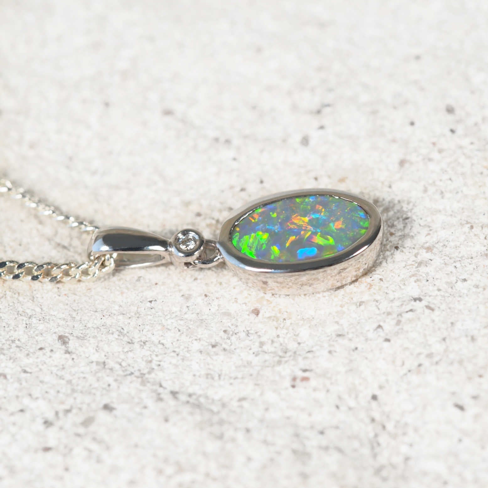 Elegant 14ct white gold opal pendant showcasing oval solid semi-black opal from Lightning Ridge and white diamond