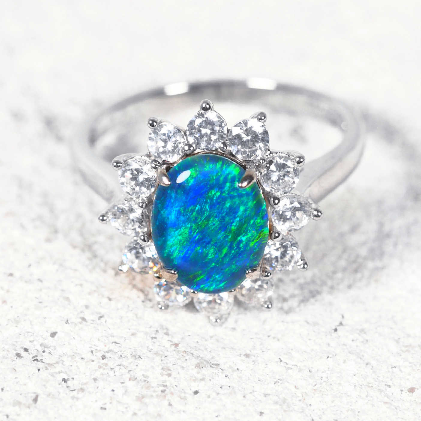 Ring with a blue opal stone and diamond-like crystals on a light background