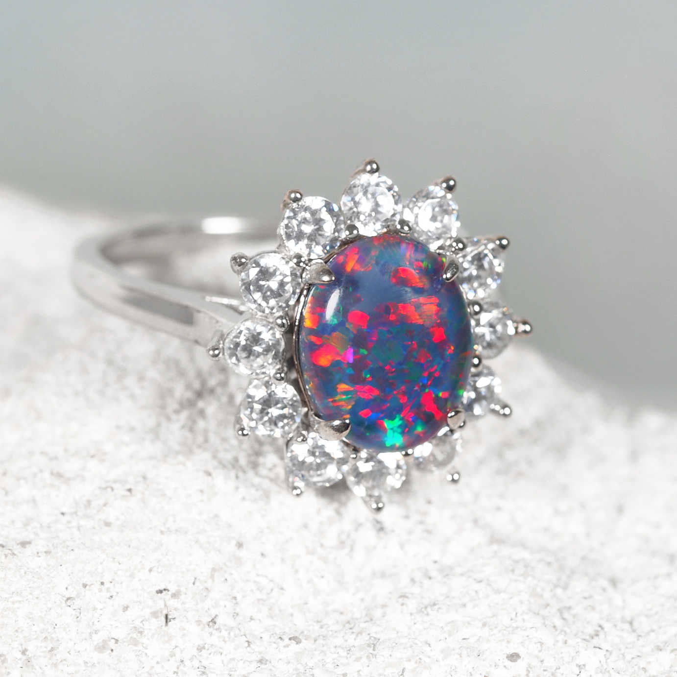 Sparkling silver opal ring with a halo of crystals