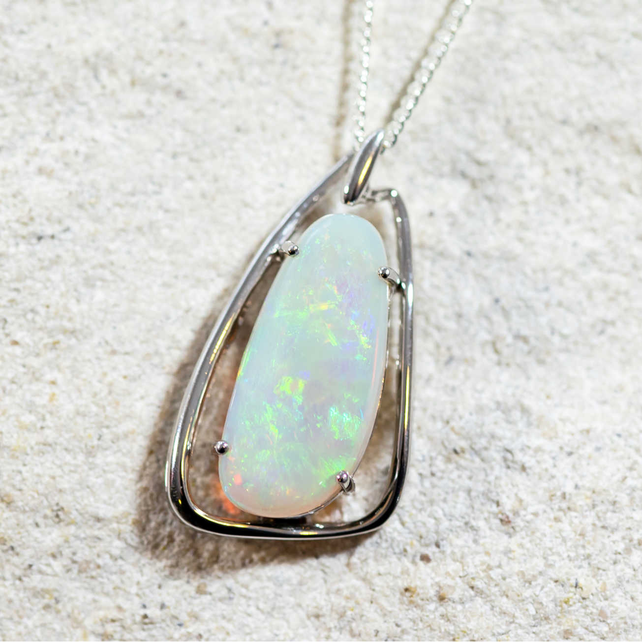 sterling silver necklace pendant claw set with a multi-coloured freeform-shaped South Australian solid crystal opal.