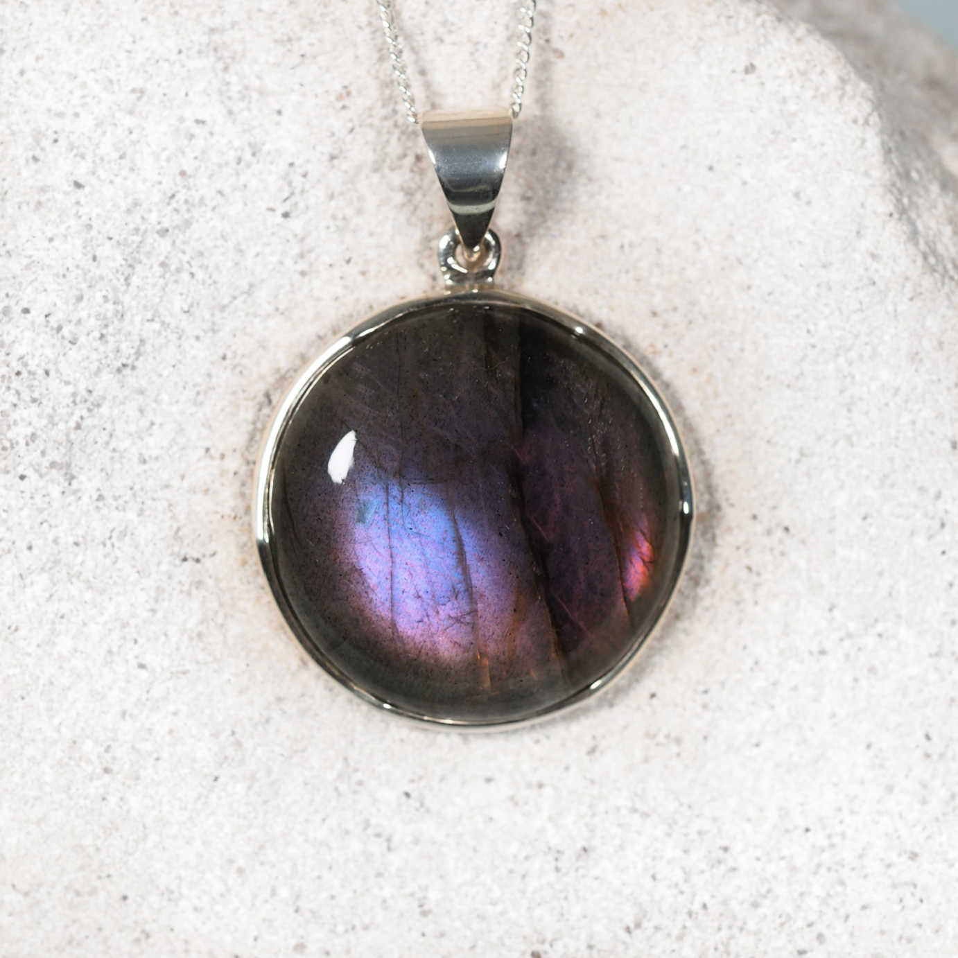 Grace Labradorite Pendant in sterling silver with a smooth round gemstone showing hints of purple and a small amount of blue