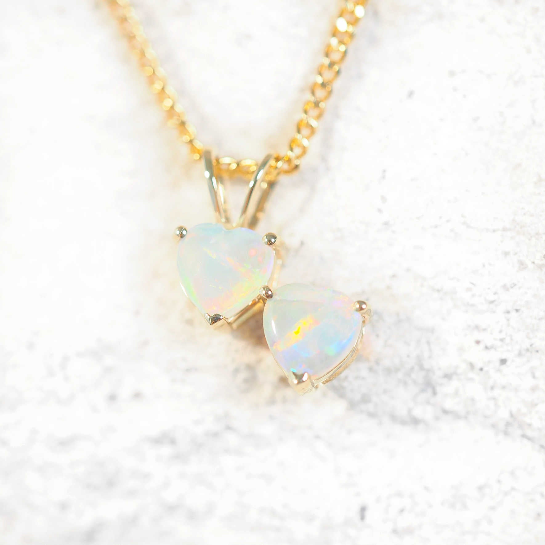 9ct yellow gold opal necklace featuring two heart-shaped South Australian solid crystal opals with multi-coloured fire, on a gold-plated chain