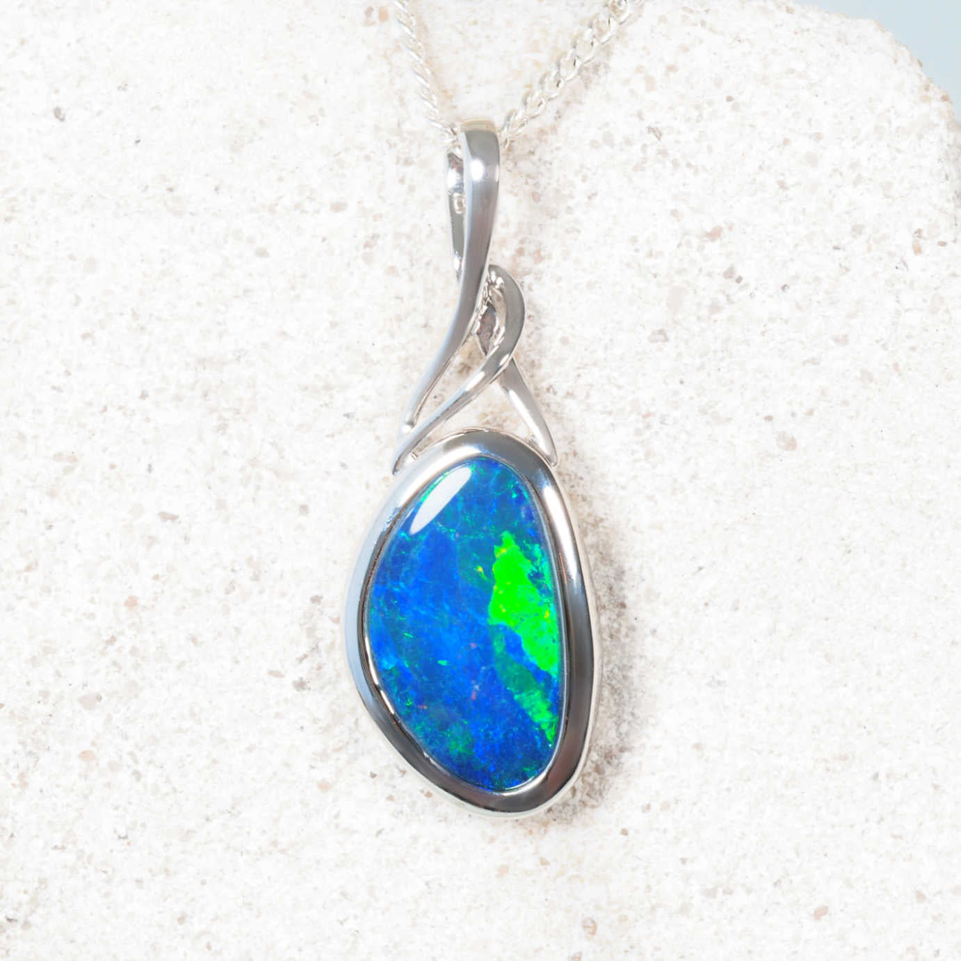 Modern white gold opal necklace featuring vivid blue-green Australian opal