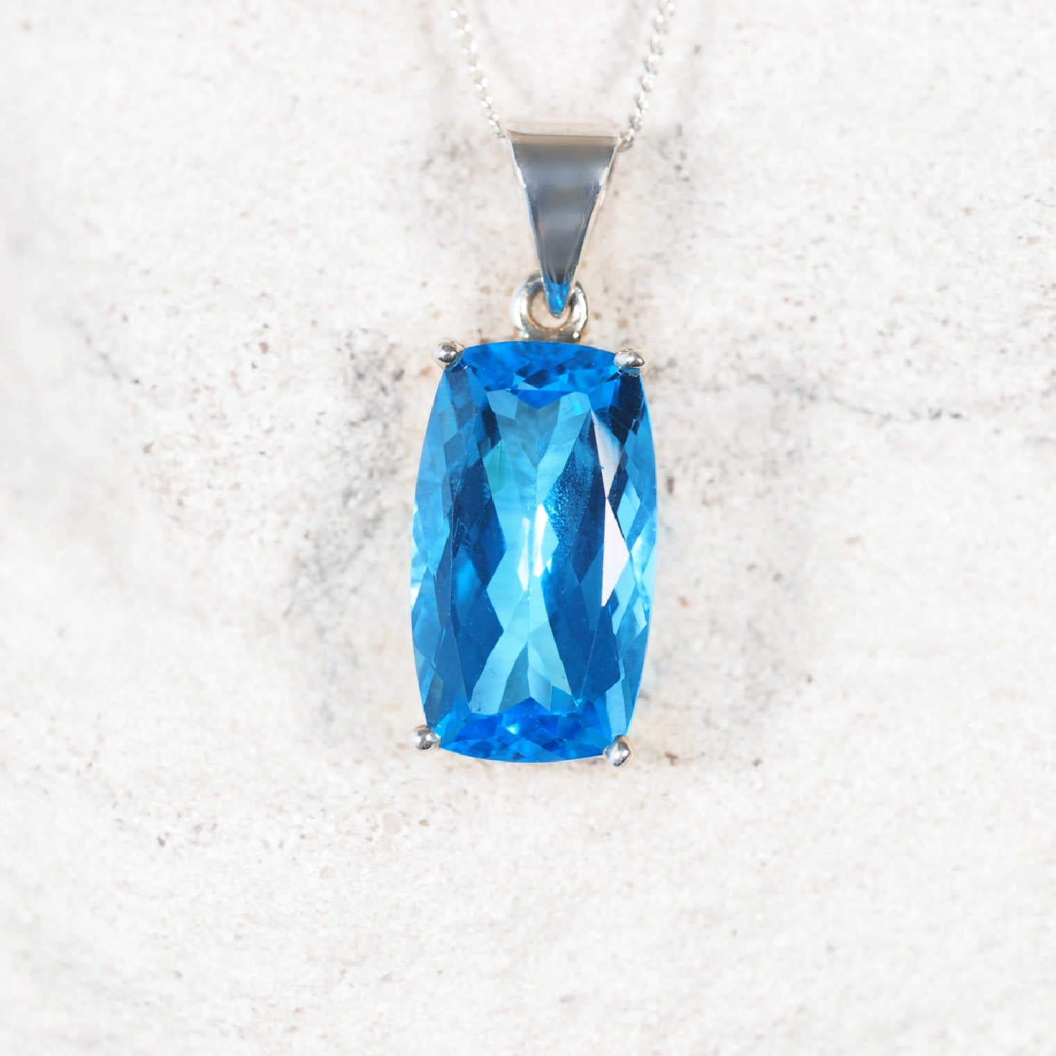 Faceted Blue Topaz Silver Pendant with a claw set bezel, setting the stone to secures