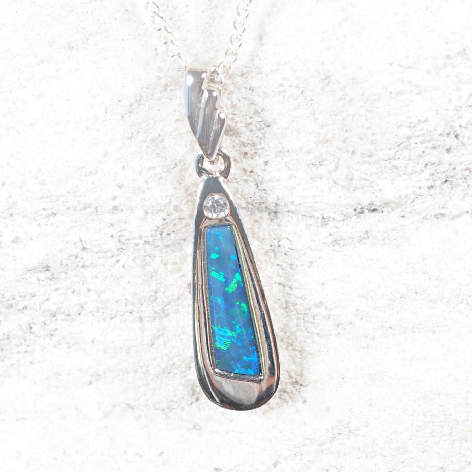 Opal pendant with silver setting on a white background