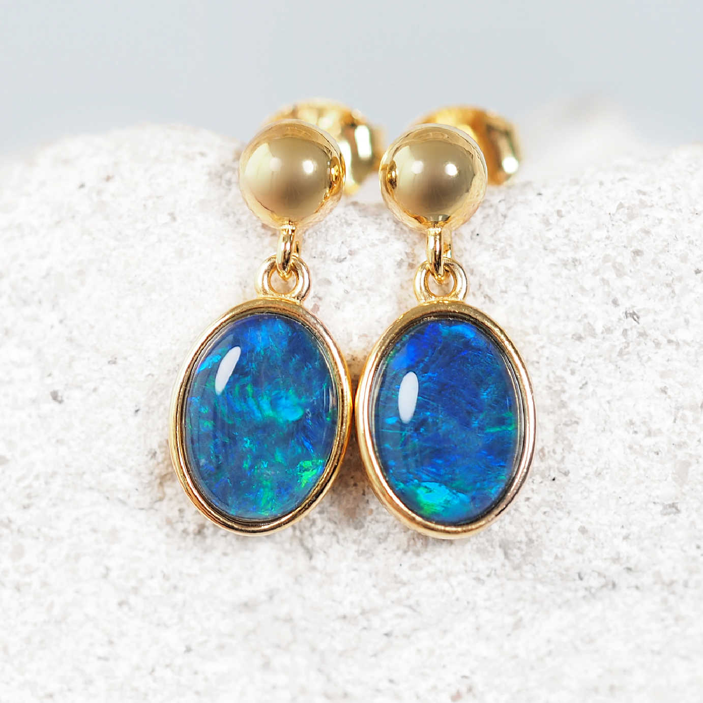 Gold bezel-set triplet opal earrings with vivid blue and green colour play