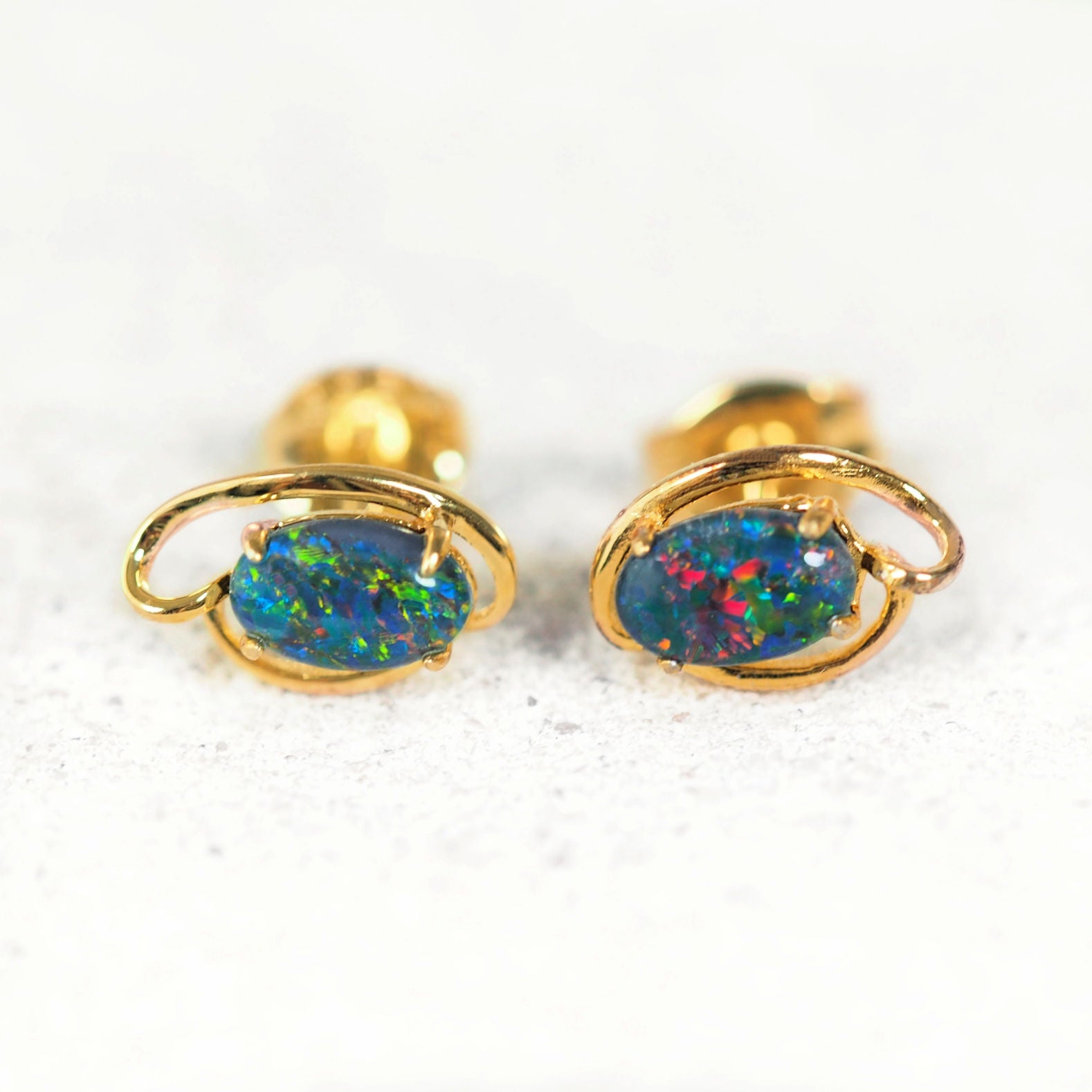 Delicate gold-plated oval opal earrings with colourful Australian triplet stones.