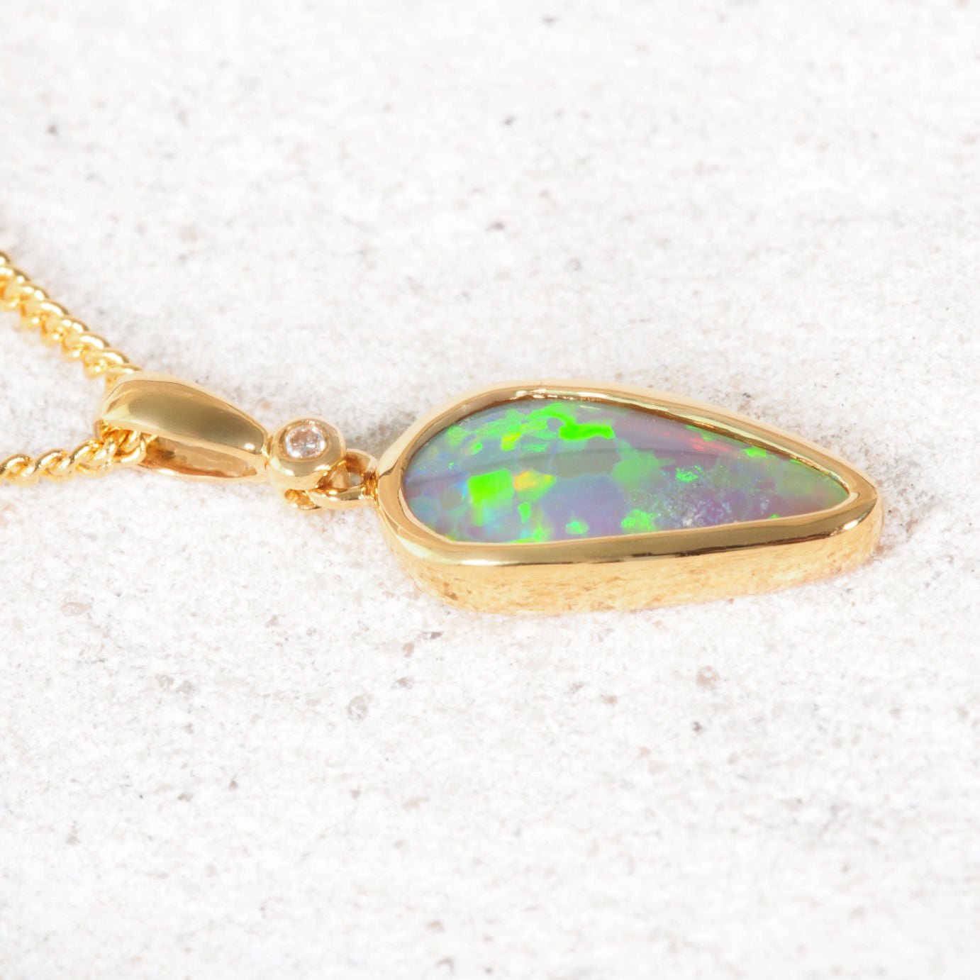 Lightning Ridge black crystal opal pendant in 18ct yellow gold bezel setting with diamond