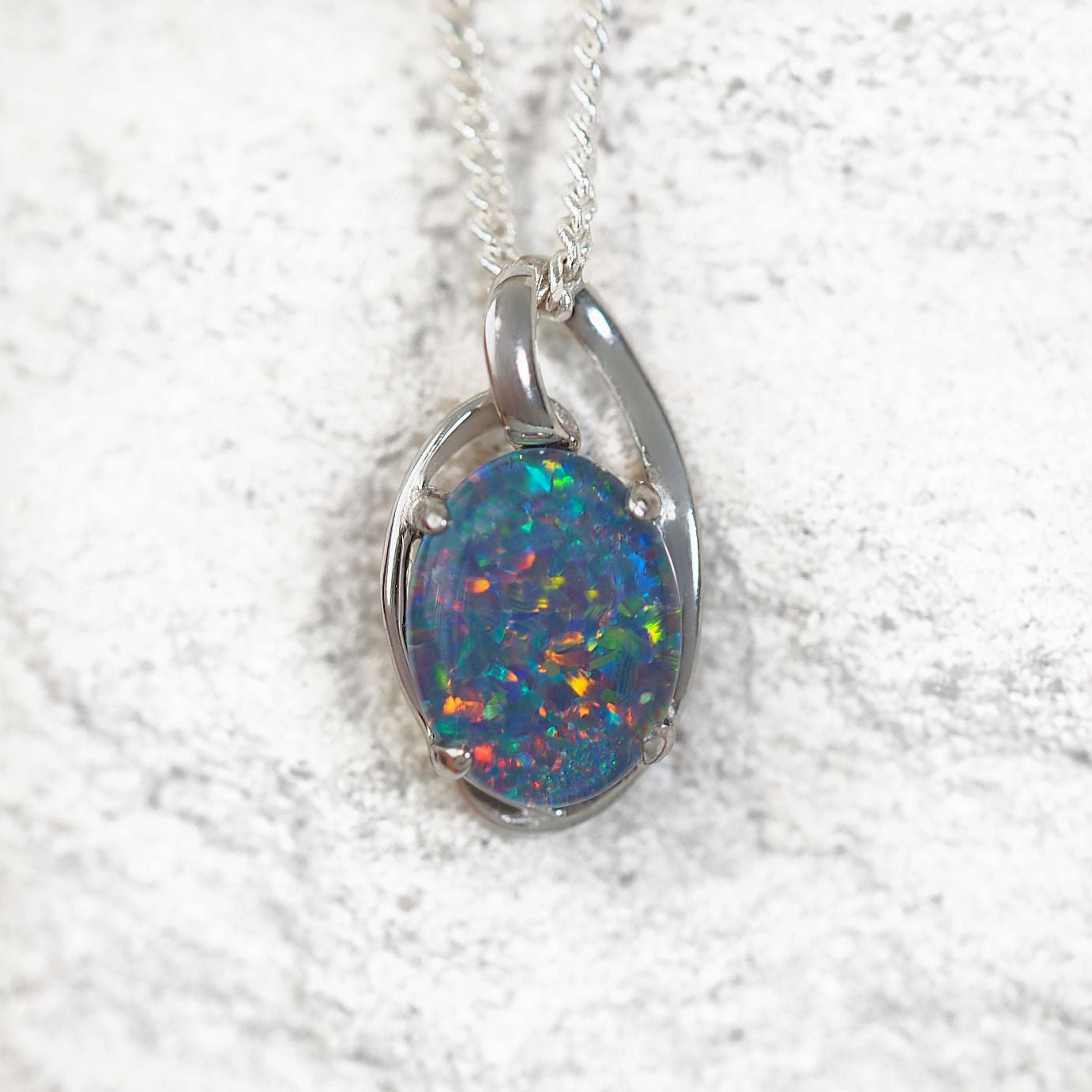 'Kylan' opal pendant in sterling silver with claw-set oval Australian triplet opal showcasing vibrant multi-coloured flashes