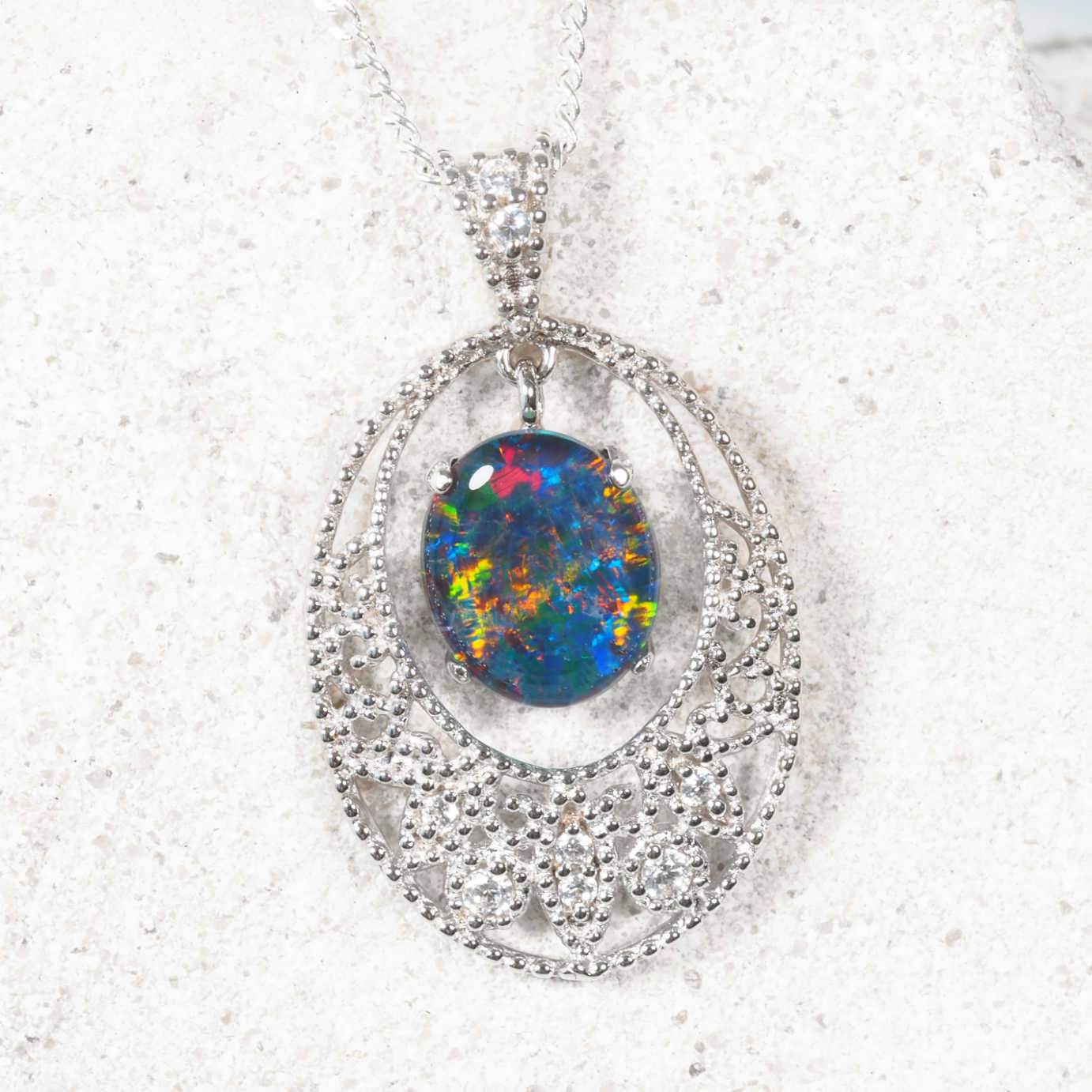 Elegant silver opal necklace featuring floral-patterned oval Australian triplet opal surrounded by cubic zirconias